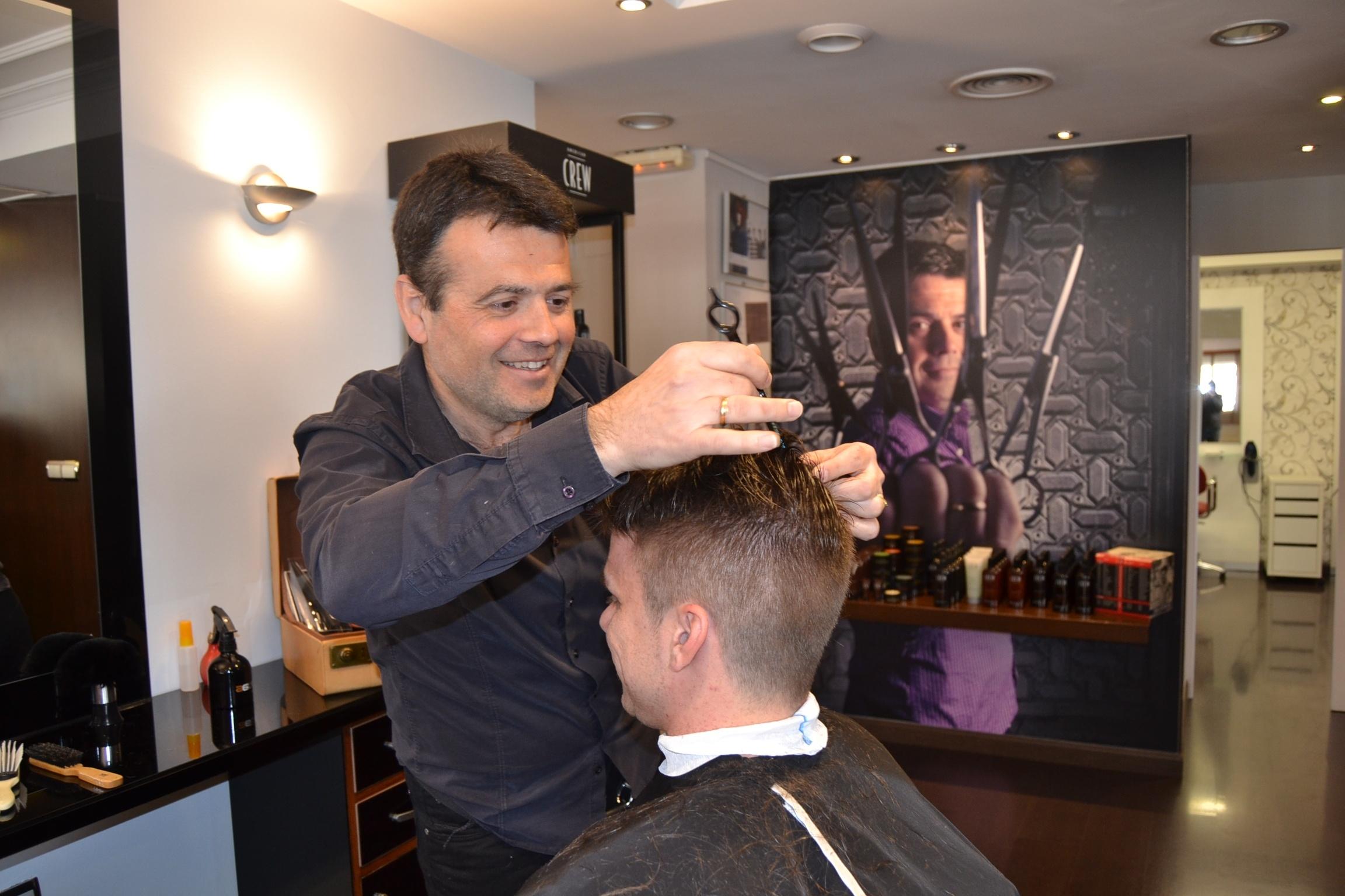 Un peluquero corta el pelo a un hombre. Fuente: EP.