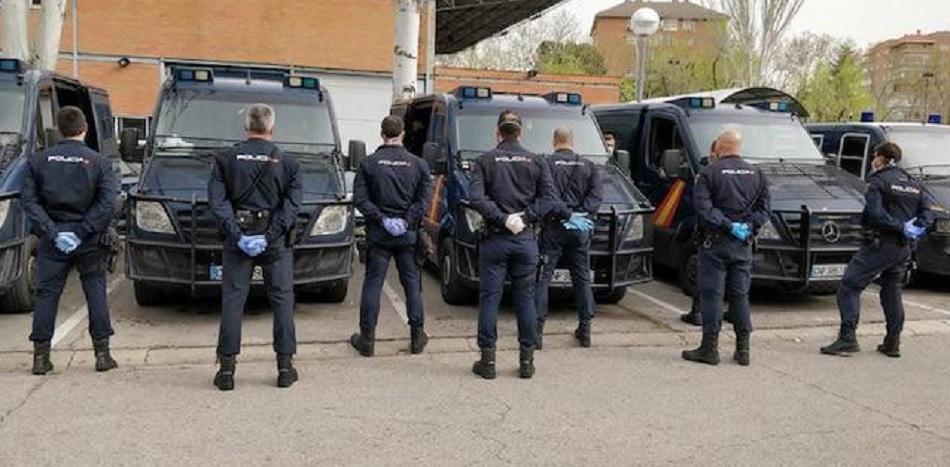 Policías nacionales ante los furgones policiales