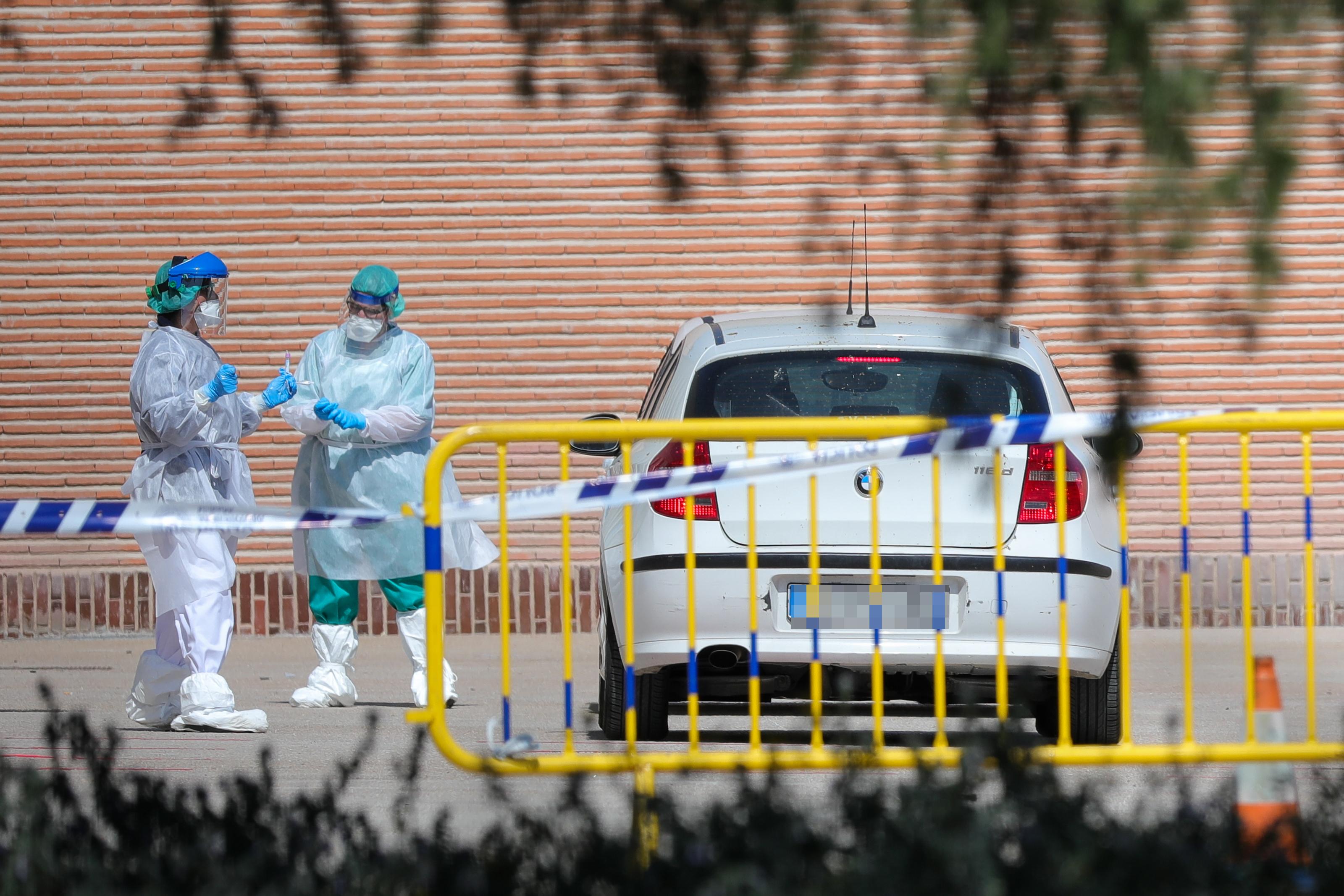 Dos profesionales sanitarios junto a un vehículo