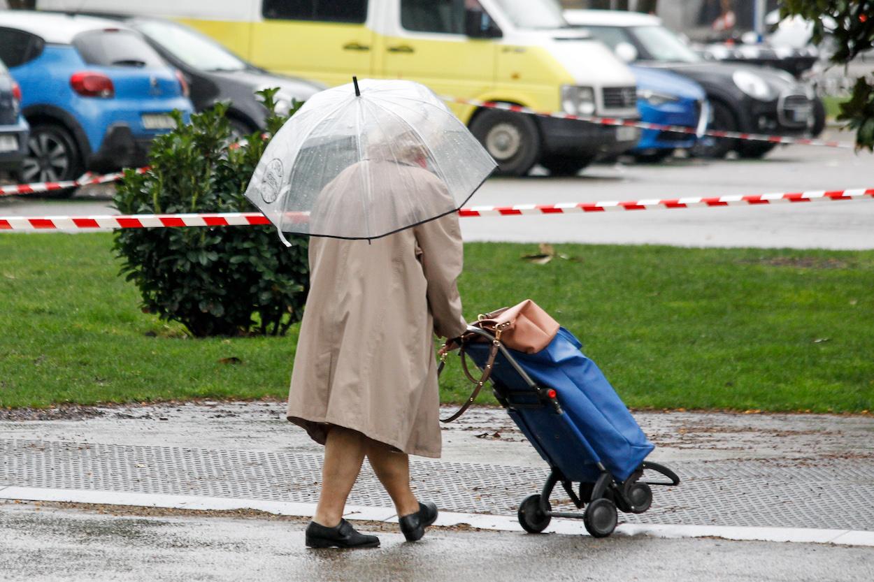 Una mujer se protege de la lluvia de Madrid.
