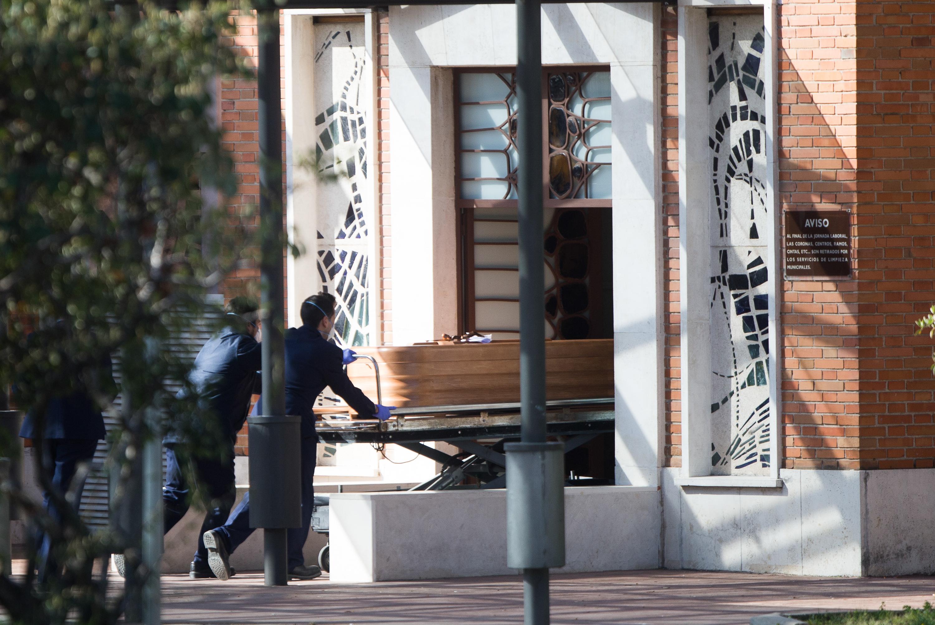 Dos trabajadores de la funeraria de Madrid con un ataúd. EUROPAPRESS