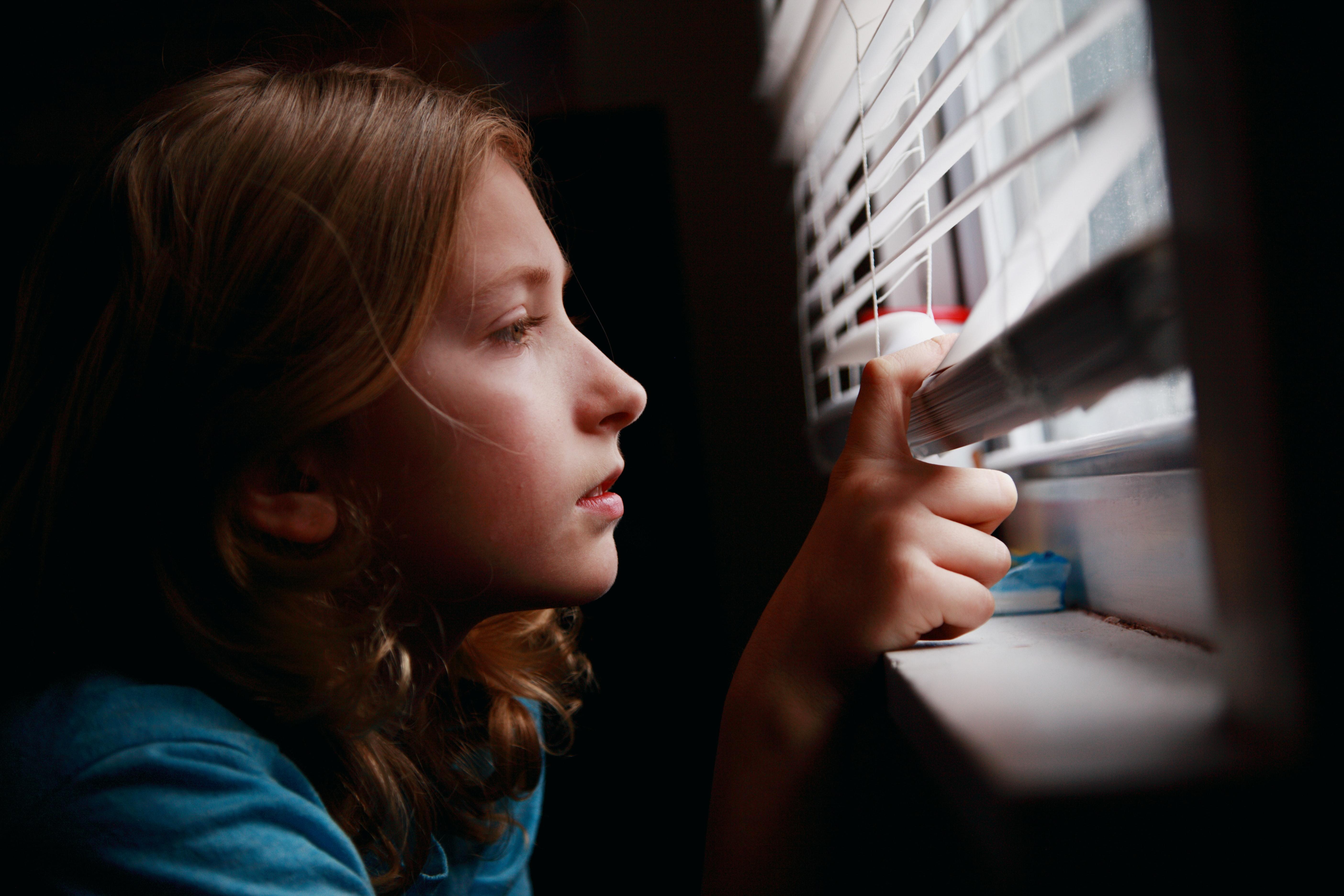 Una niña mira por la ventana desde su casa. Sharon Mccutcheon para Unsplash