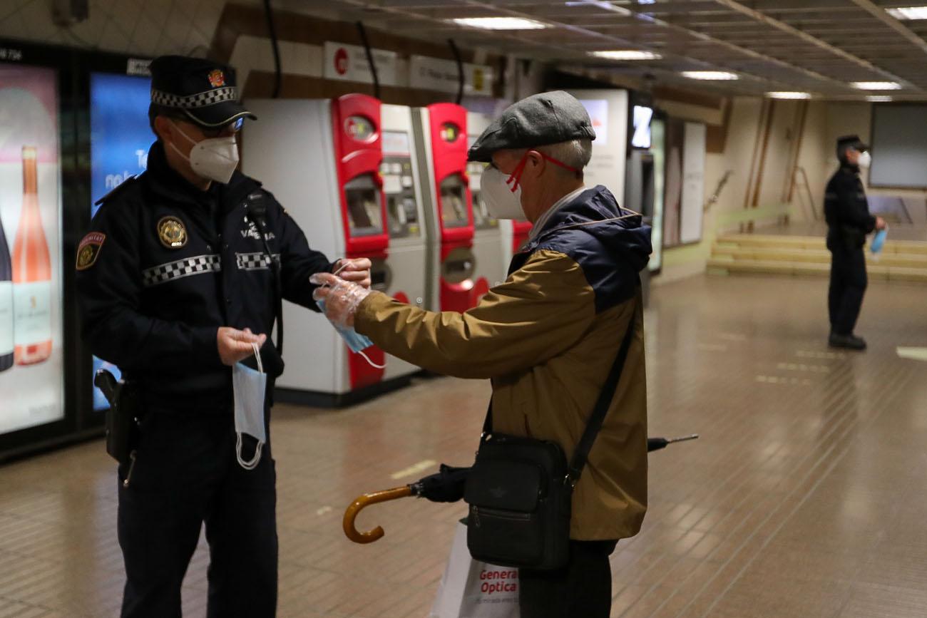 Un policía da una mascarilla a un señor en Madrid