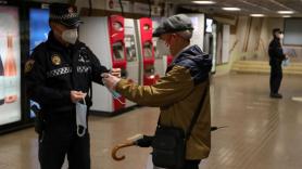 Un policía da una mascarilla a un señor en Madrid