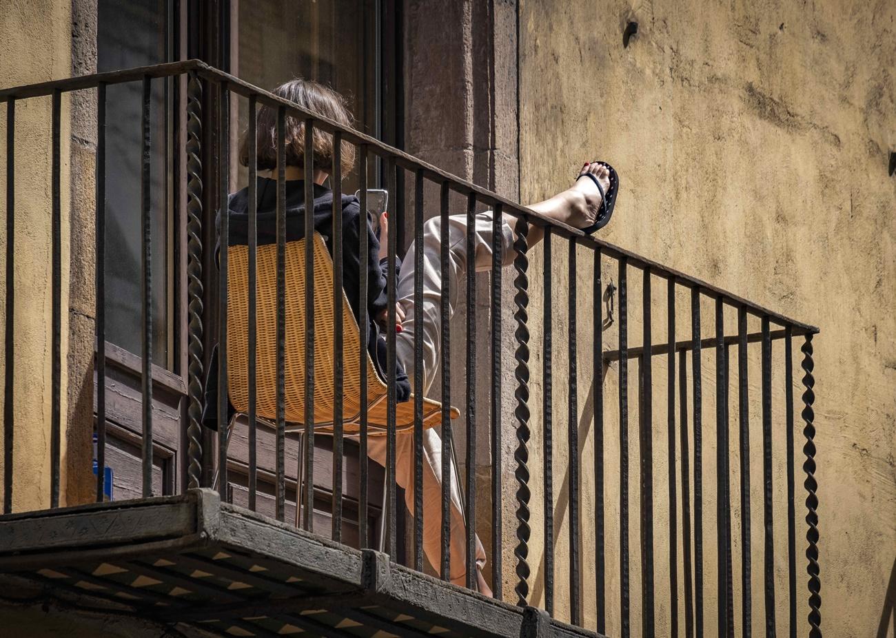 Una mujer toma el sol en el balcón en Barcelona