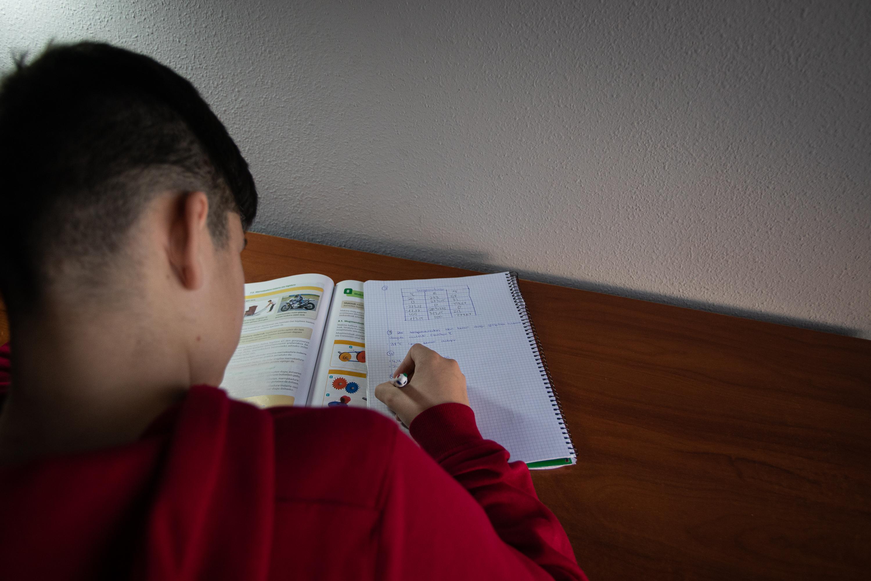 Un niño realiza sus deberes en su habitación durante el confinamiento por el estado de alarma