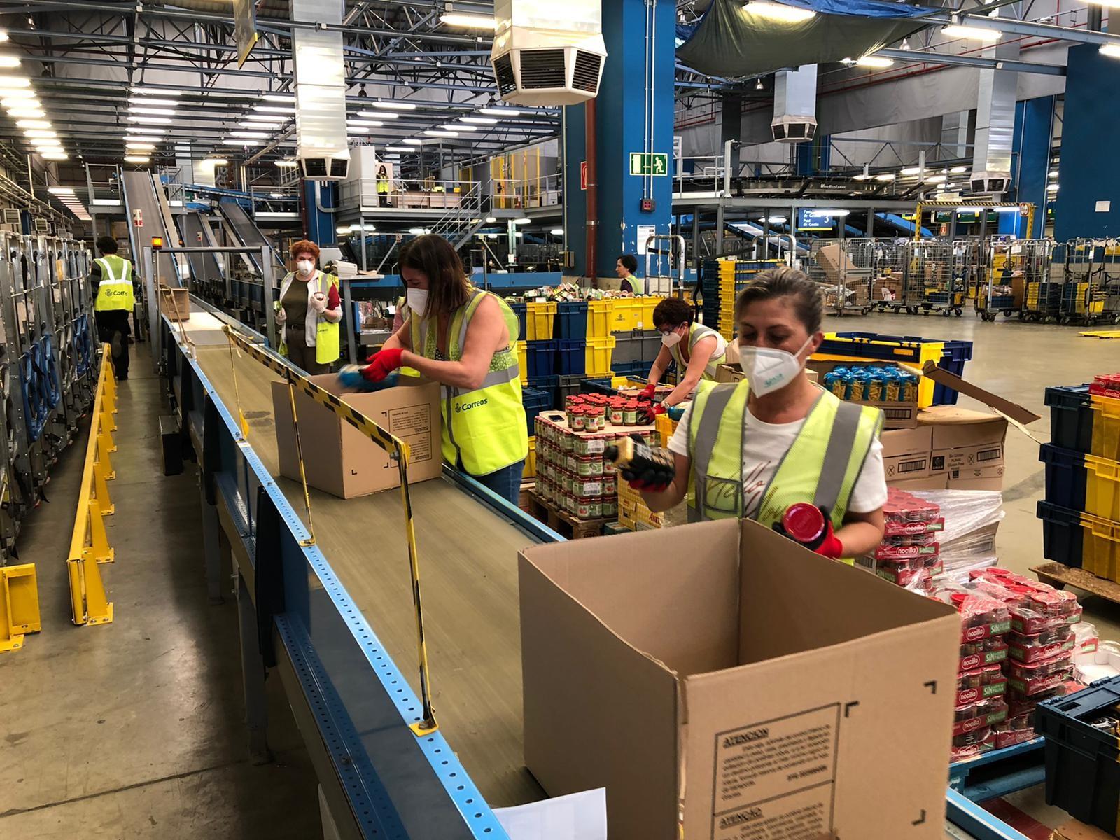 Trabajadores preparando los pedidos en el almacén de Correos