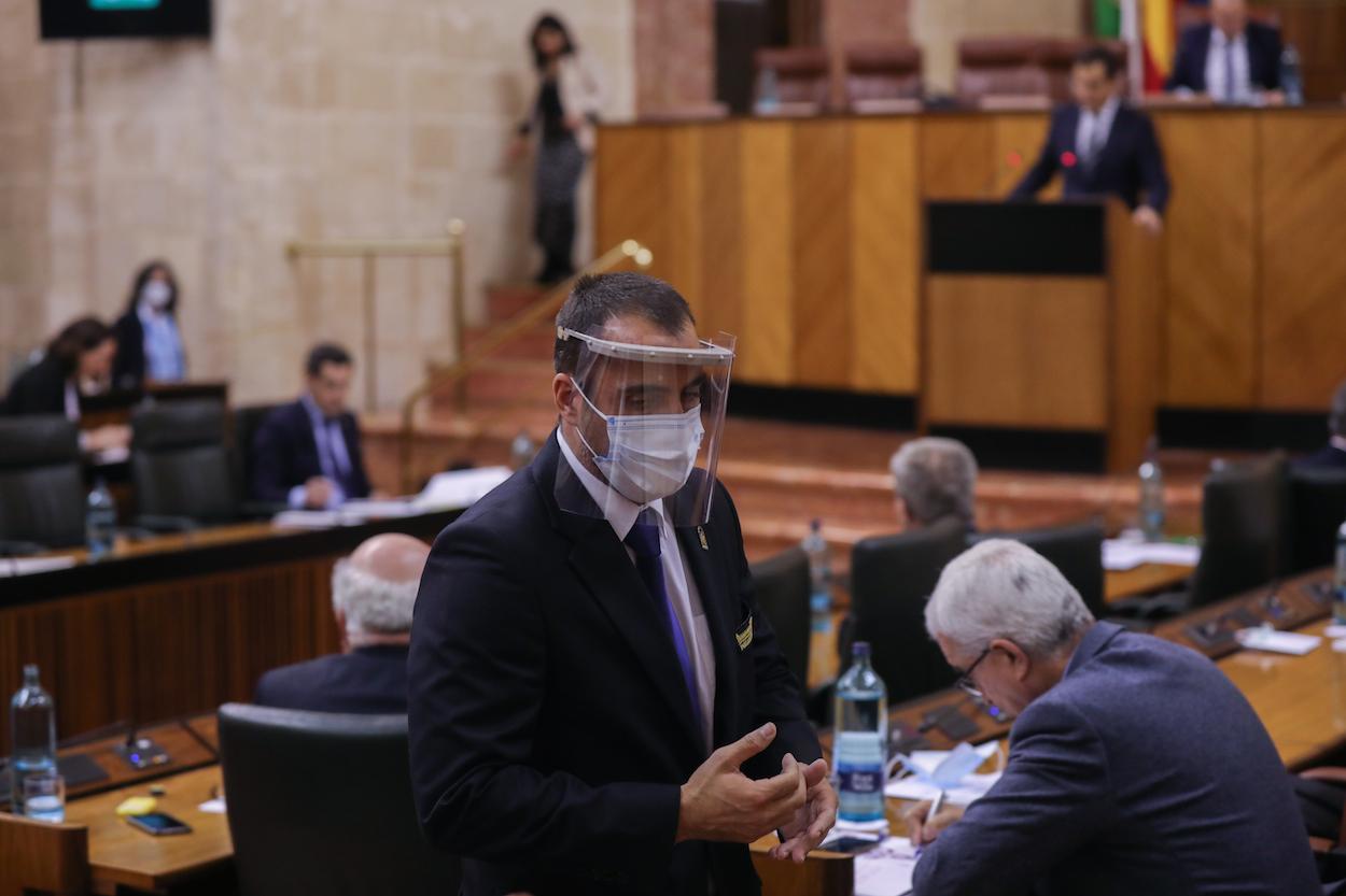 Un ujier del Parlamento protegido con mascarilla y pantalla de seguridad, durante sesión de la Diputación Permanente del Parlamento. MARÍA JOSÉ LÓPEZ/EP
