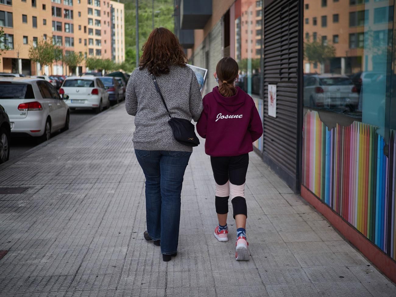 Una madre paseando junto a su hija. 