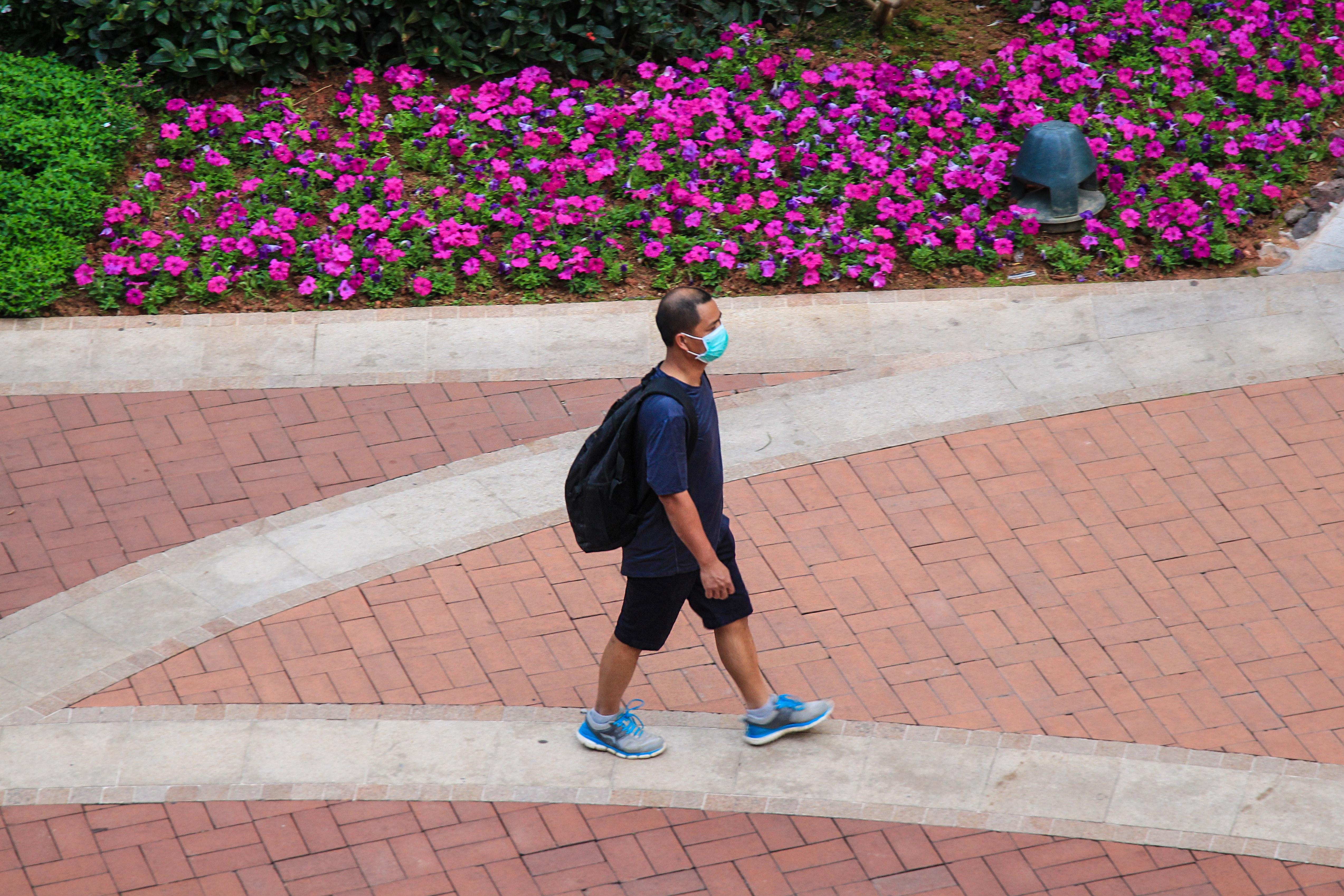 Hombre caminando con mascarilla. Macau Photo Agency para Unsplash