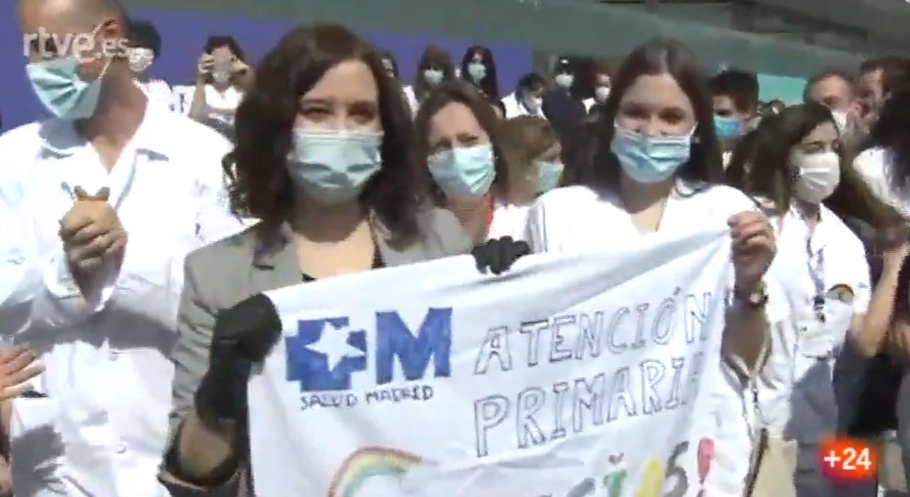 La presidenta de la Comunidad de Madrid, Isabel Díaz Ayuso, porta una pancarta de apoyo a la Atención Primaria. Fuente: Twitter.