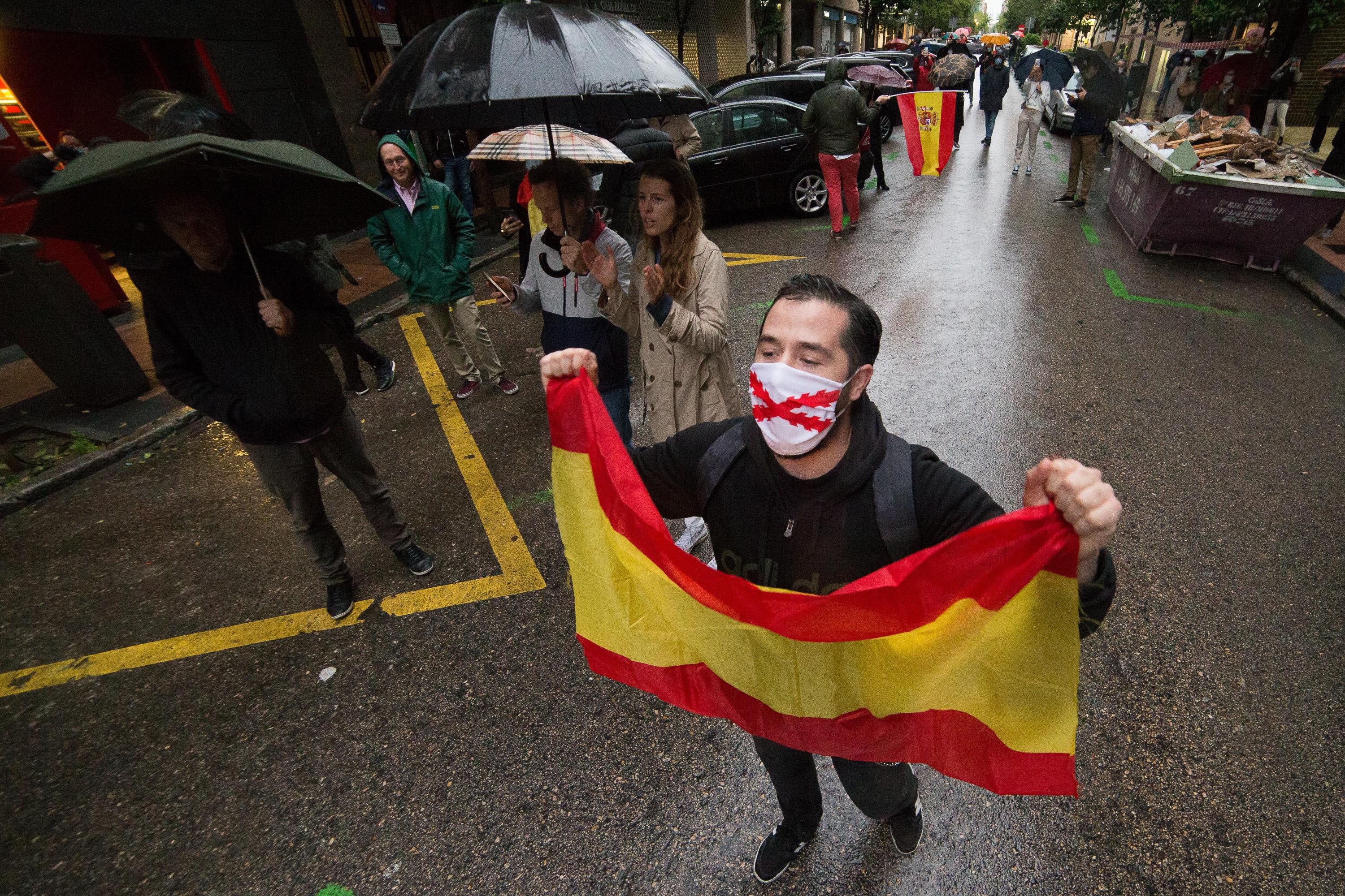 Un hombre con mascarilla levanta una bandera de España en señal de protesta durante la concentración de los vecinos del barrio madrileño de Salamanca en la calle Núñez de Balboa el pasado mayo por la gestión del Gobierno contra el coronavirus