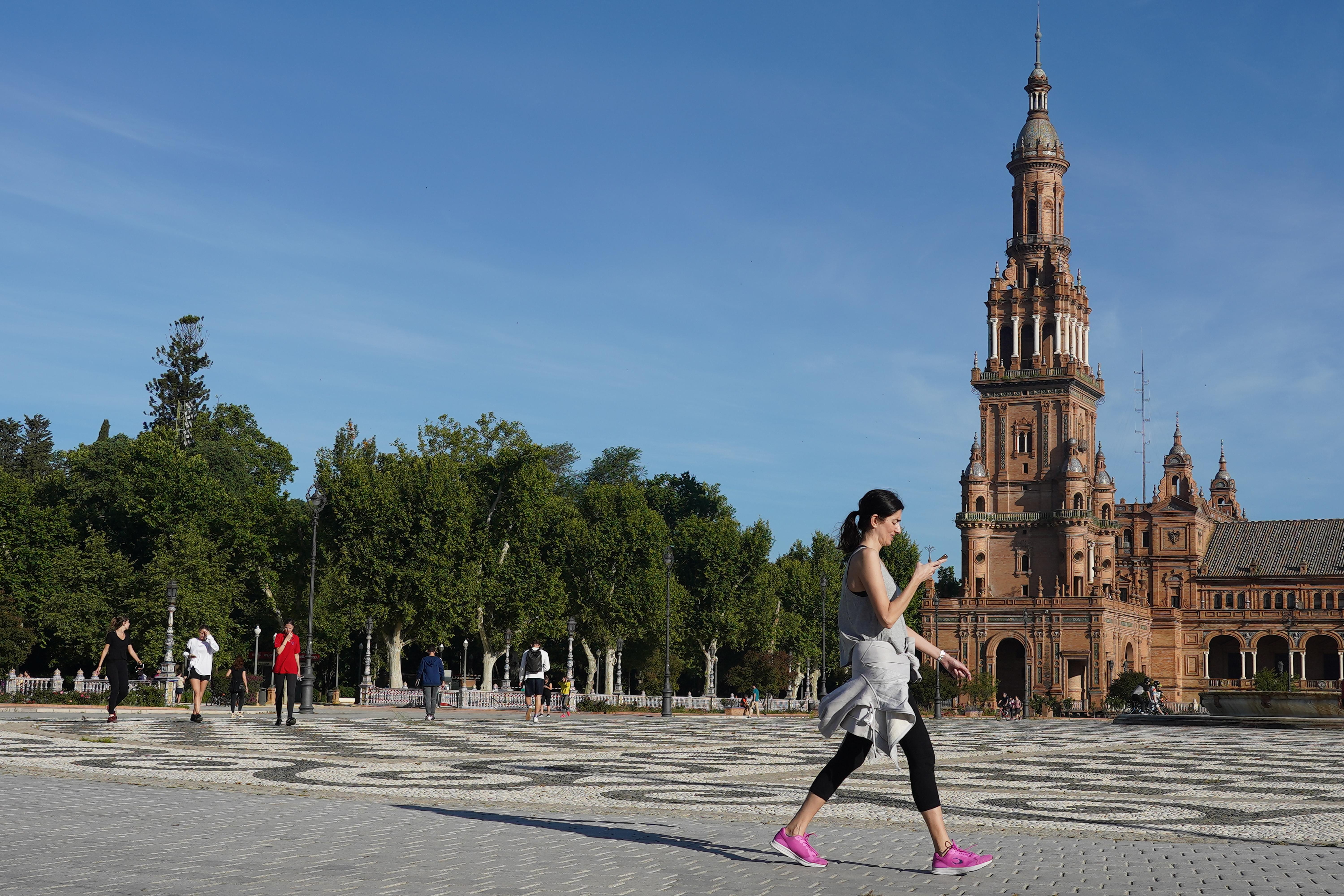 Una joven pasea por la Plaza de España, el segundo día en que el Gobierno permite salir a hacer deporte de forma individual y pasear con otra persona con la que se conviva
