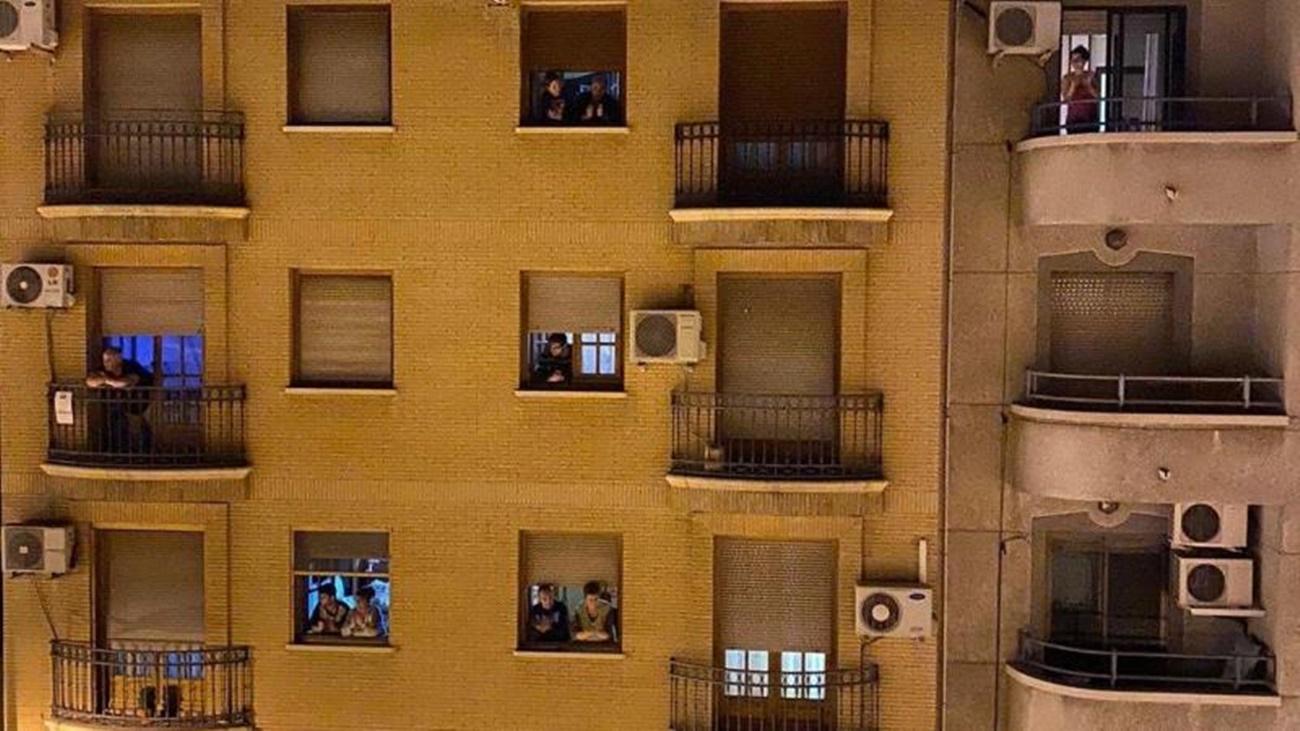 Varias personas aplauden a los sanitarios desde sus ventanas y balcones