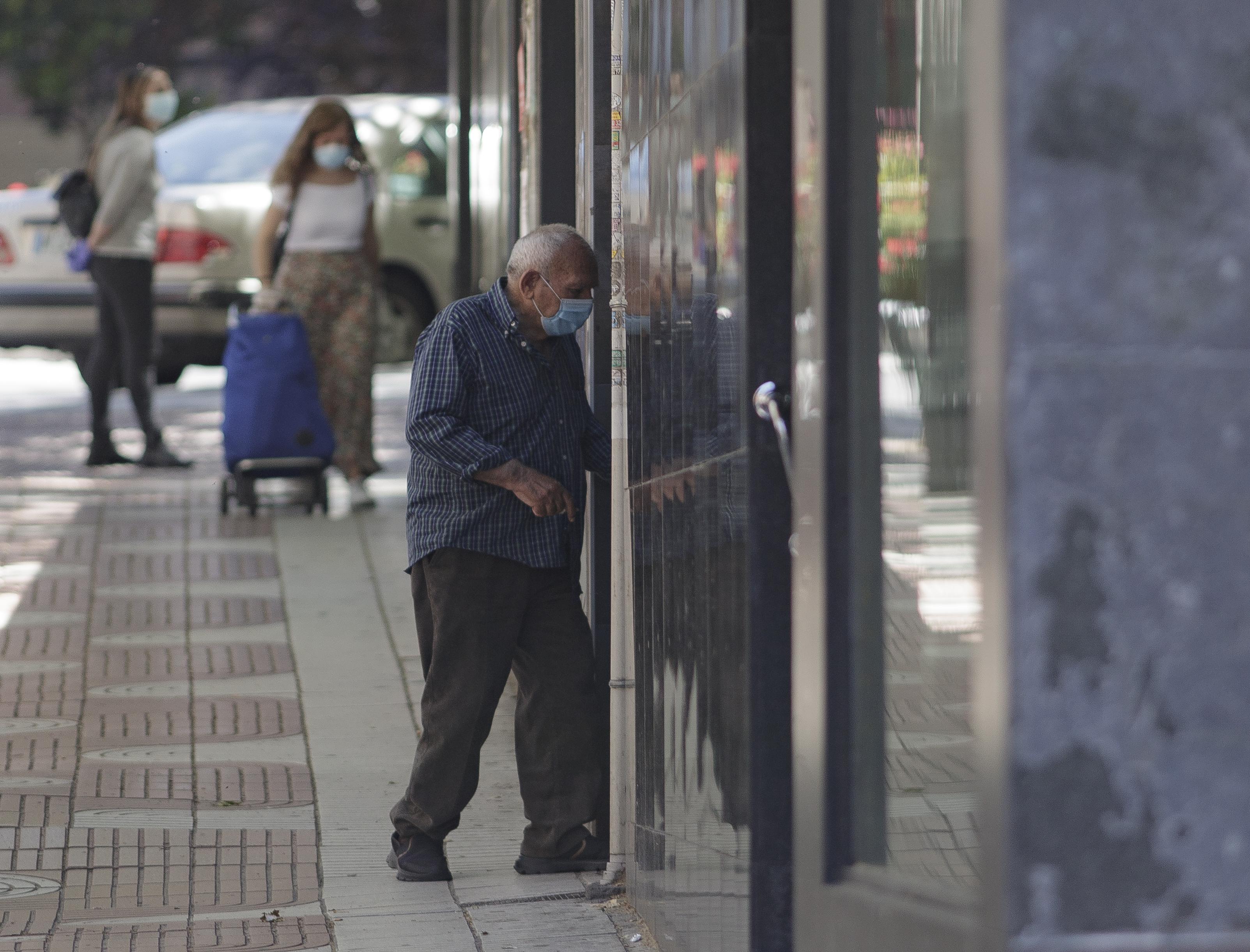 Varias personas en la calle protegidas con mascarillas. 