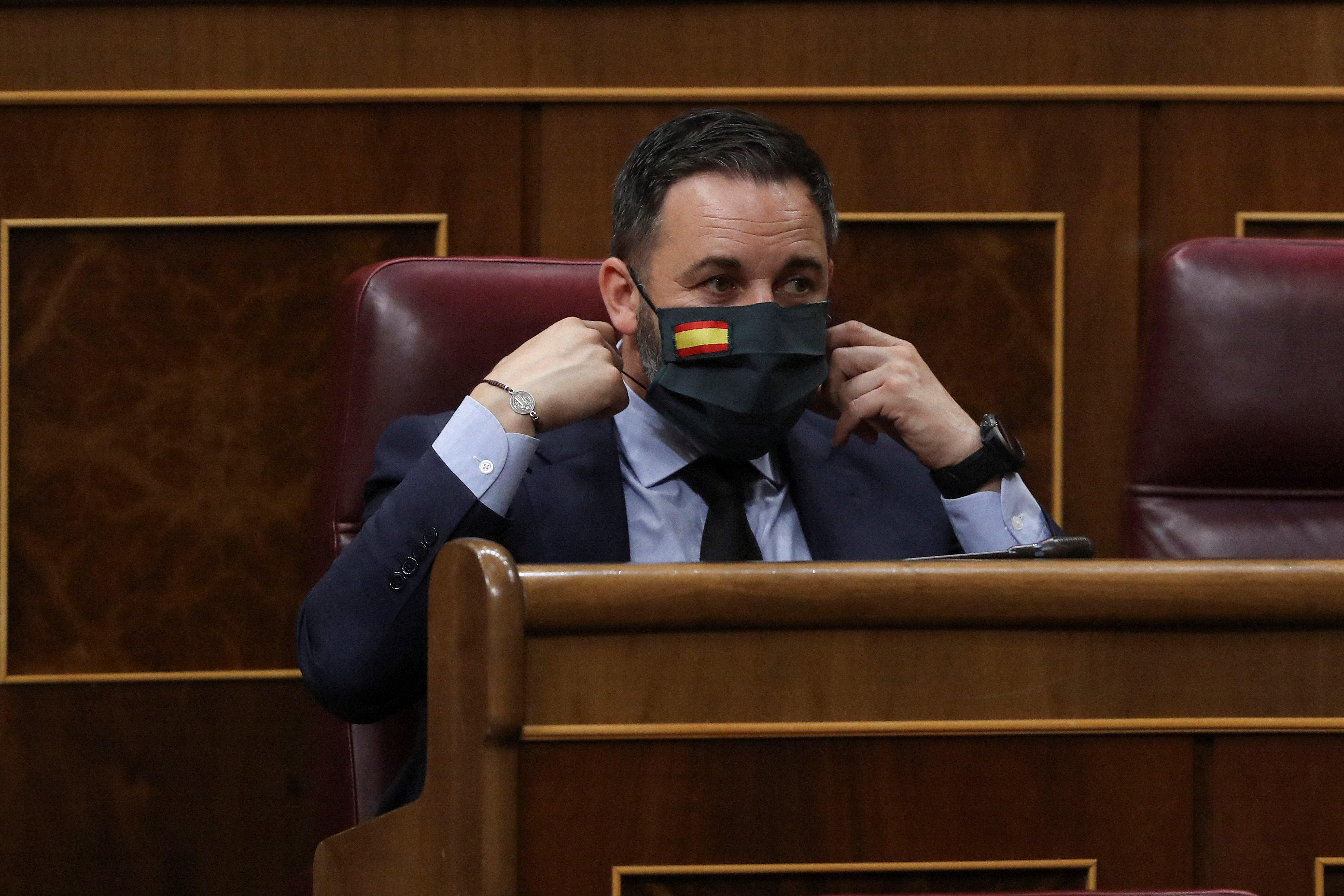 El presidente de Vox, Santiago Abascal, en el Congreso poniéndose su mascarilla personalizada con la bandera de España. Fuente: EP.