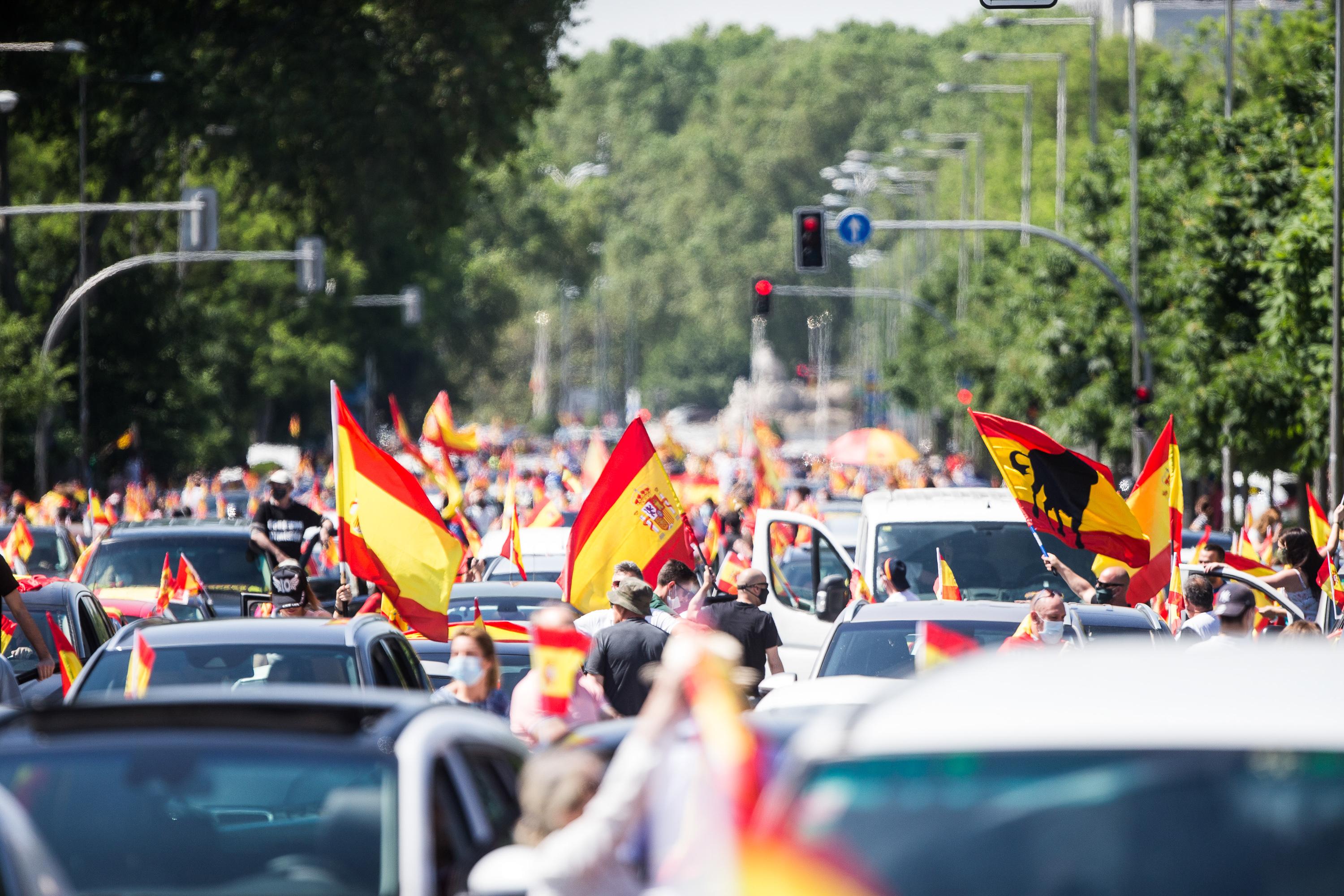 Coches y motos, con pancartas y banderas de España, circulan por las calles de la capital en la manifestación de Vox para pedir la dimisión del Gobierno de Pedro Sánchez por su gestión durante la pandemia del Covid-19