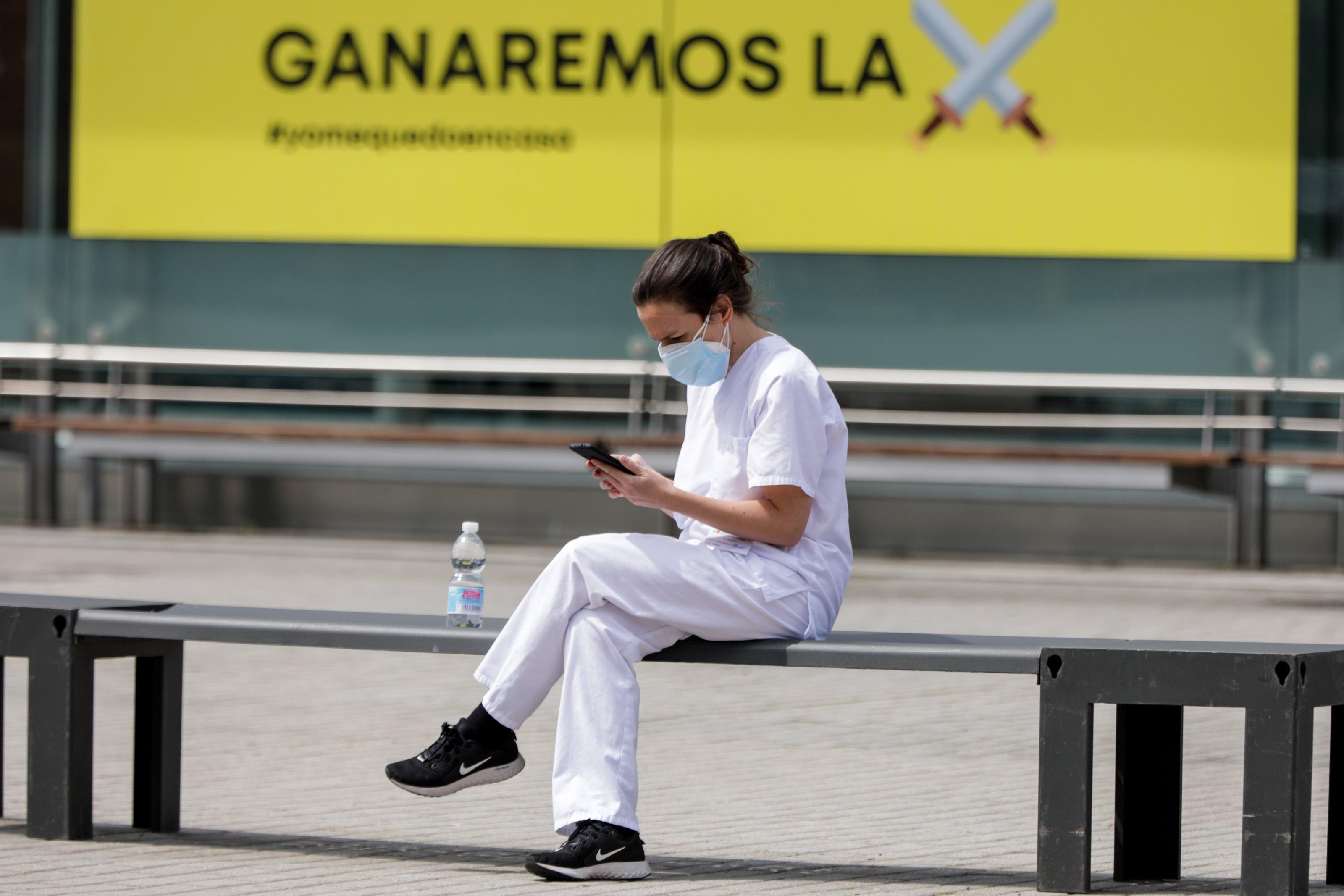 Una sanitaria chequea su teléfono móvil. Fuente: Europa Press.