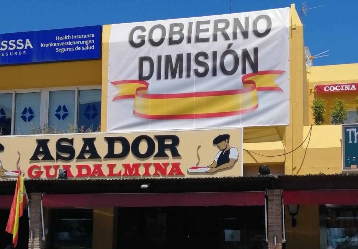 Cartel de "Gobierno Dimisión" en la fachada del Asador Guadalmina. 