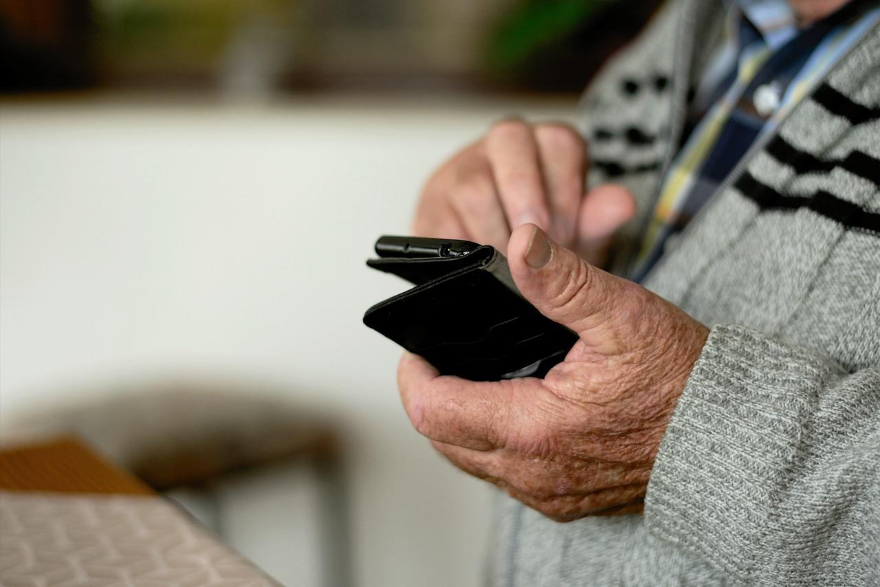 Un hombre consulta su teléfono móvil en una residencia de mayores. Fuente: Pixabay.