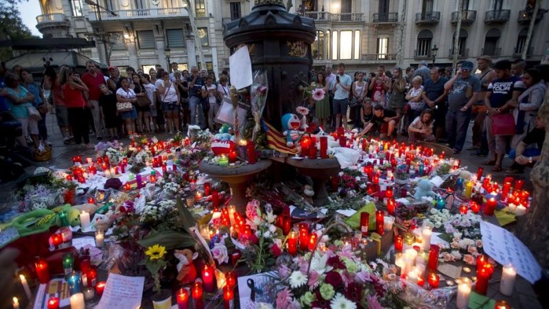 Flores y velas recuerdan en la fuente de Canaletas, en las Ramblas, a las víctimas del atentado. 