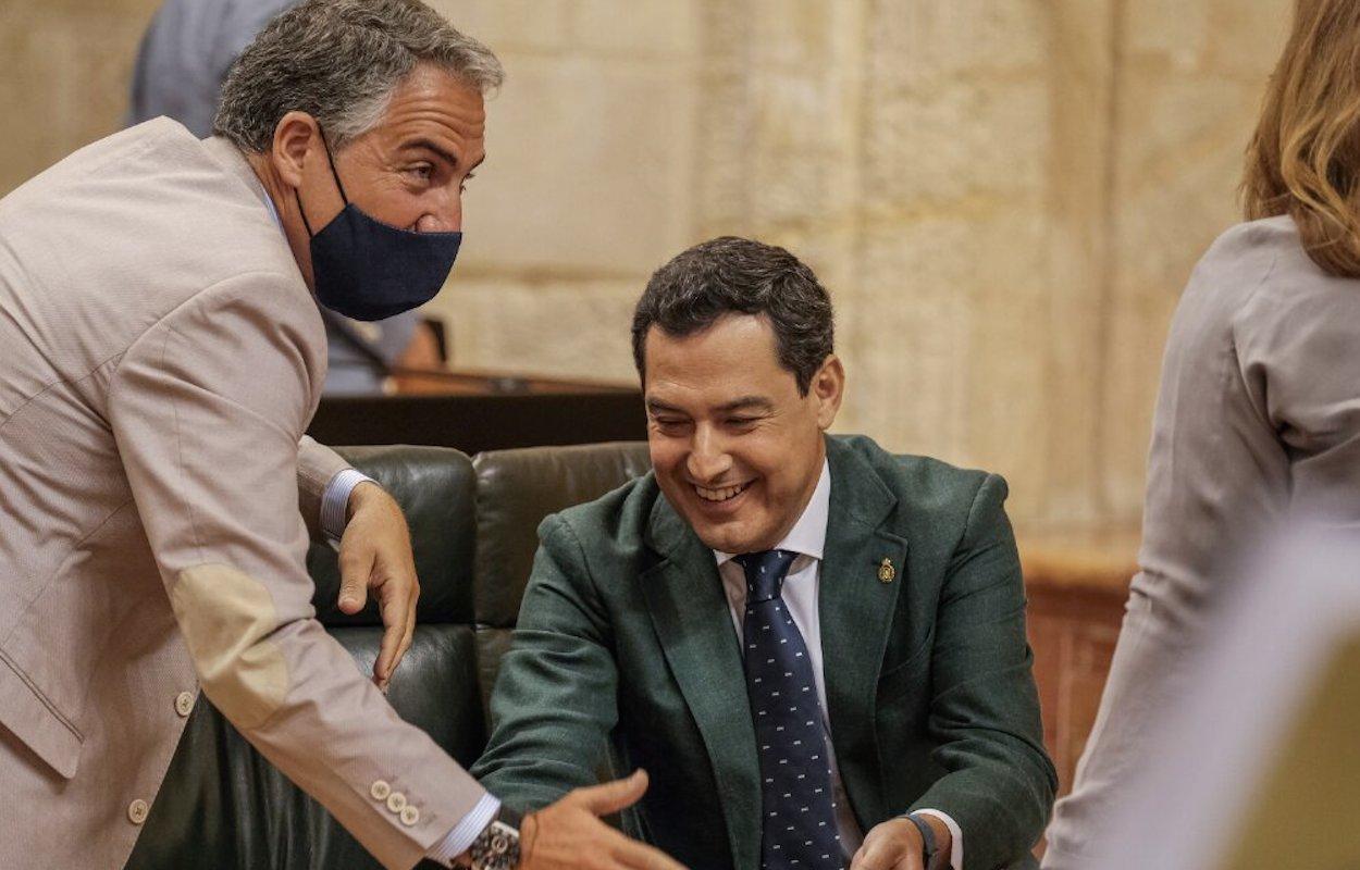 El presidente Juan Manuel Moreno y portavoz Elías Bendodo bromean durante el Pleno de hoy.