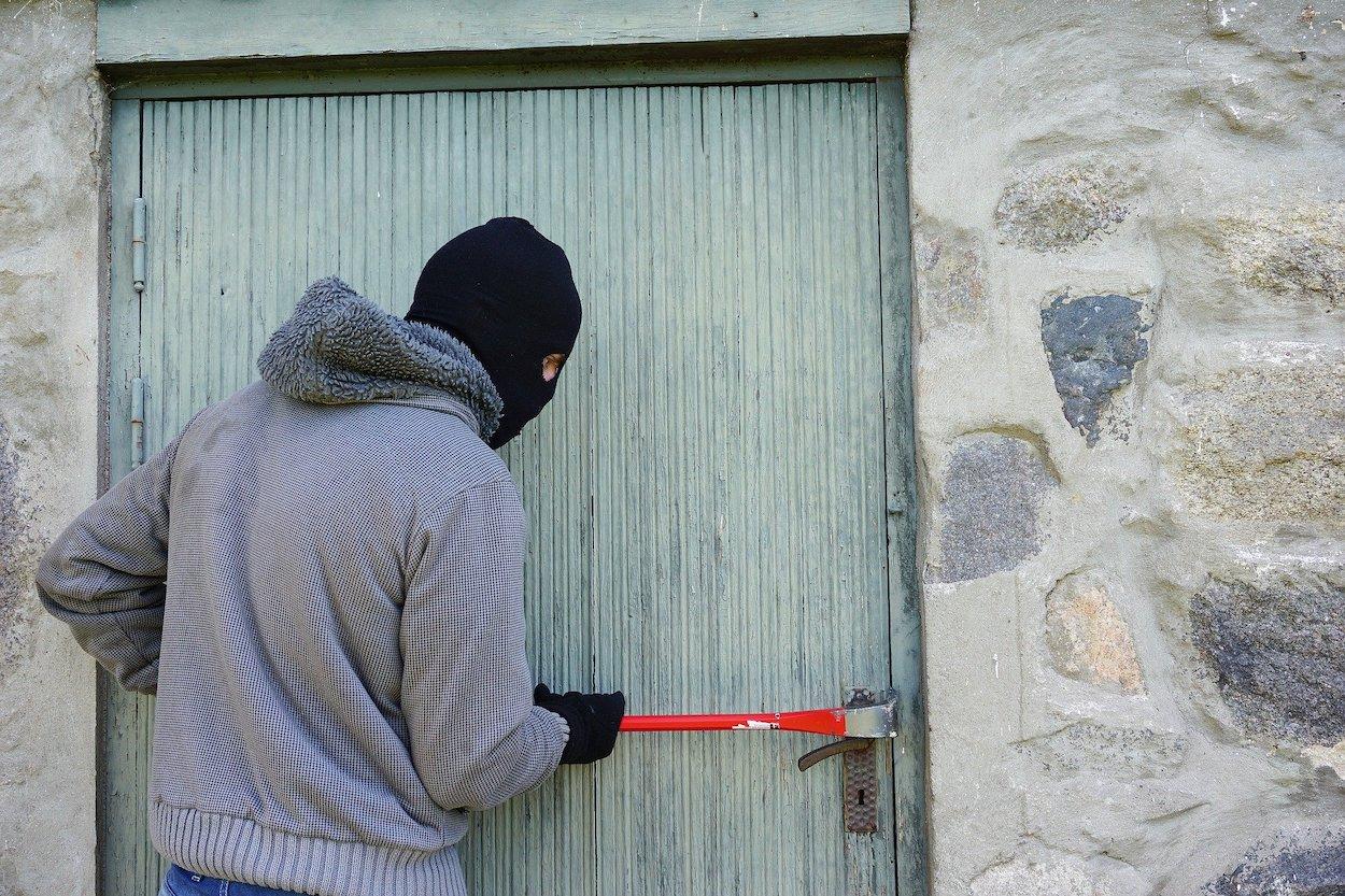 Un ladrón tratando de entrar a una casa