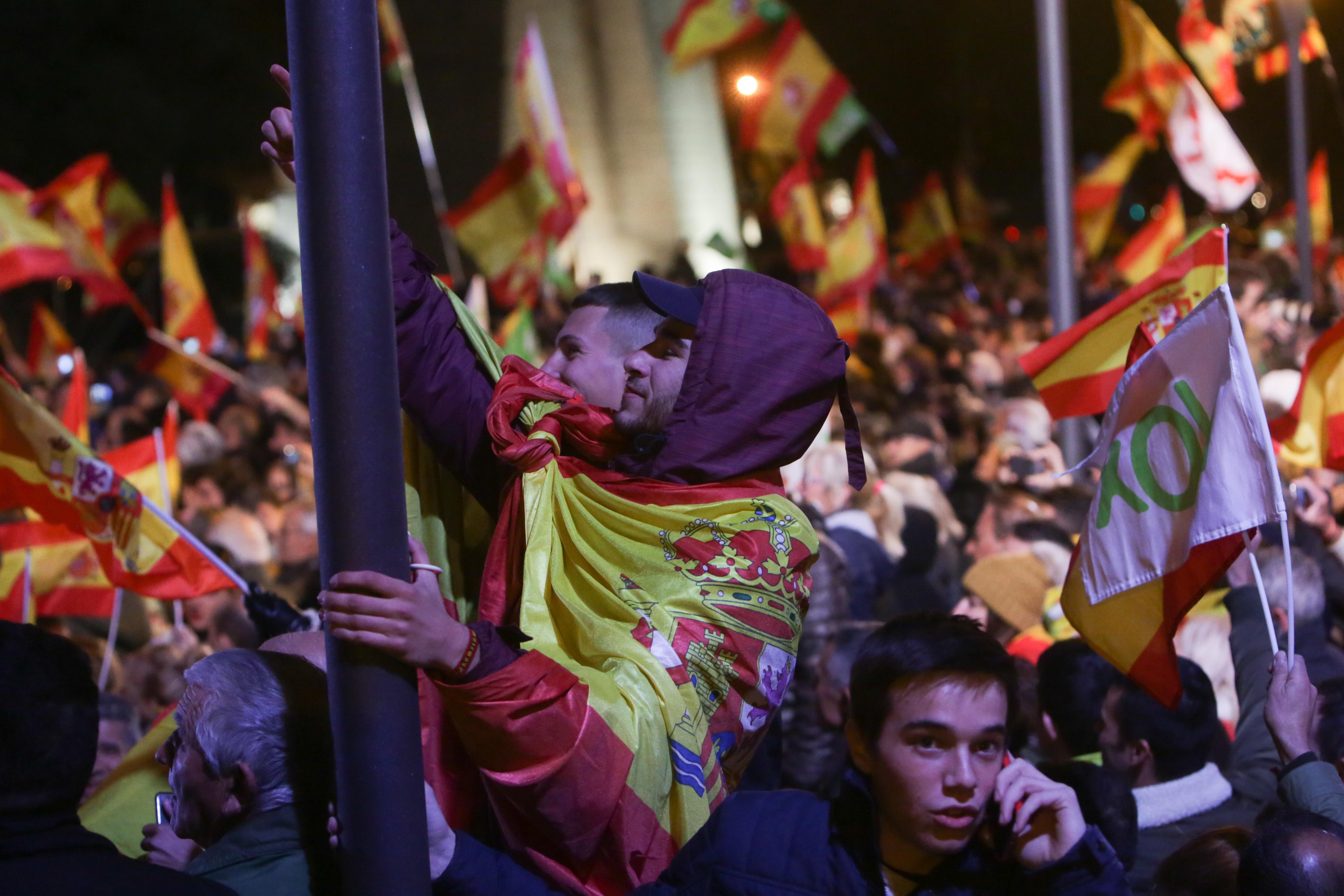 Simpatizantes de VOX con banderas de España en un mitin del partido, en la Plaza de Colón