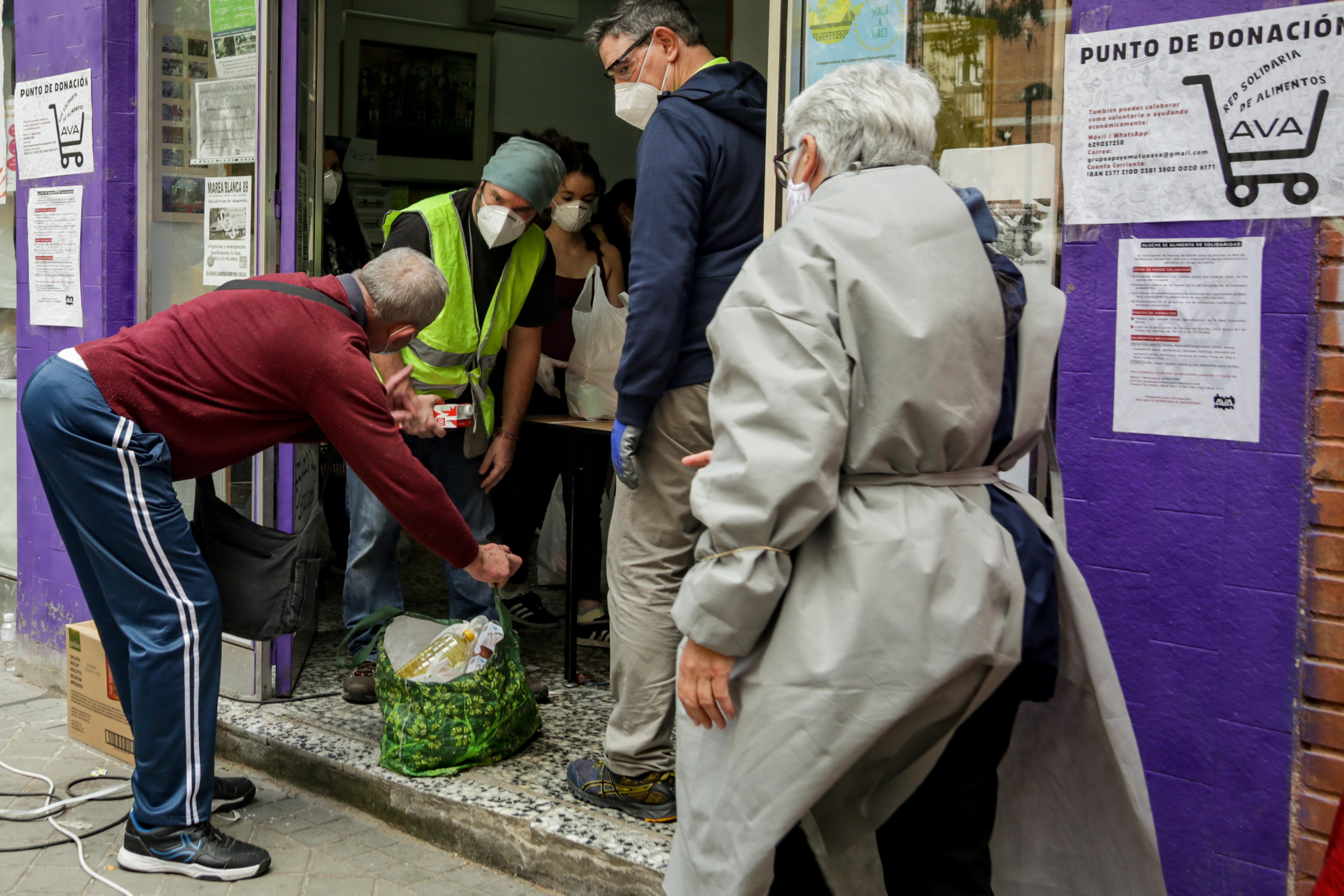Voluntarios de la Asociacion de Vecinos 'Parque Aluche' reparten alimentos por la zona. EP