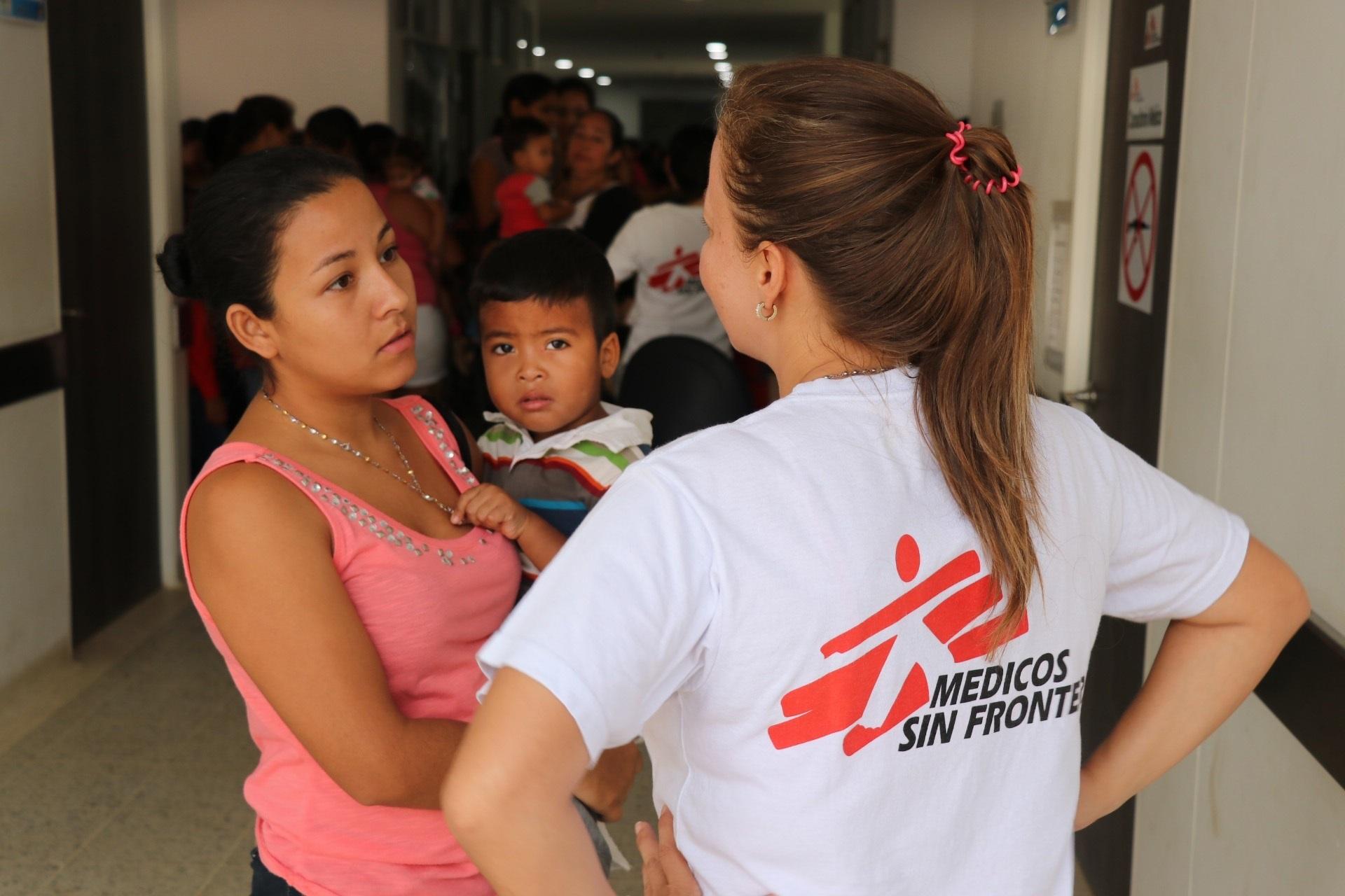 Una trabajadora de MSF habla con una mujer venezolana con un hijo. EP