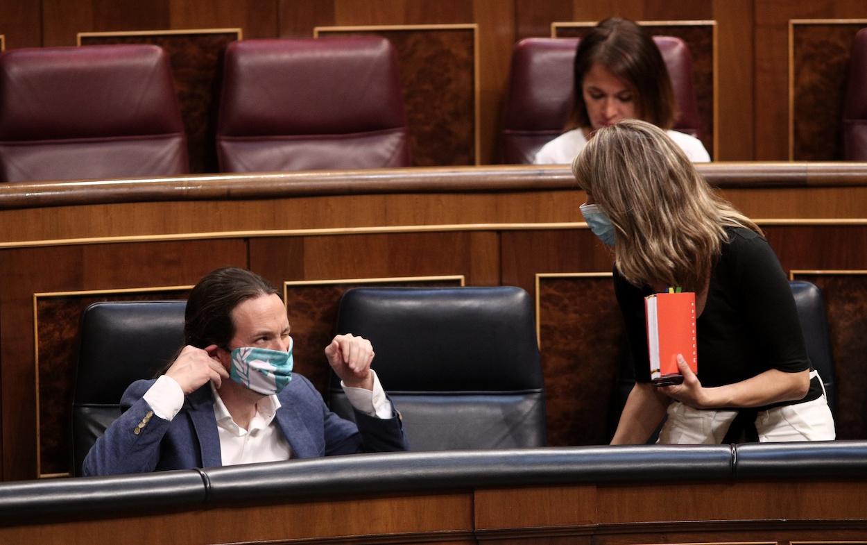 El vicepresidente segundo del Gobierno, Pablo Iglesias, protegido con mascarilla al lado de la ministra de Trabajo y Economía Social, Yolanda Díaz