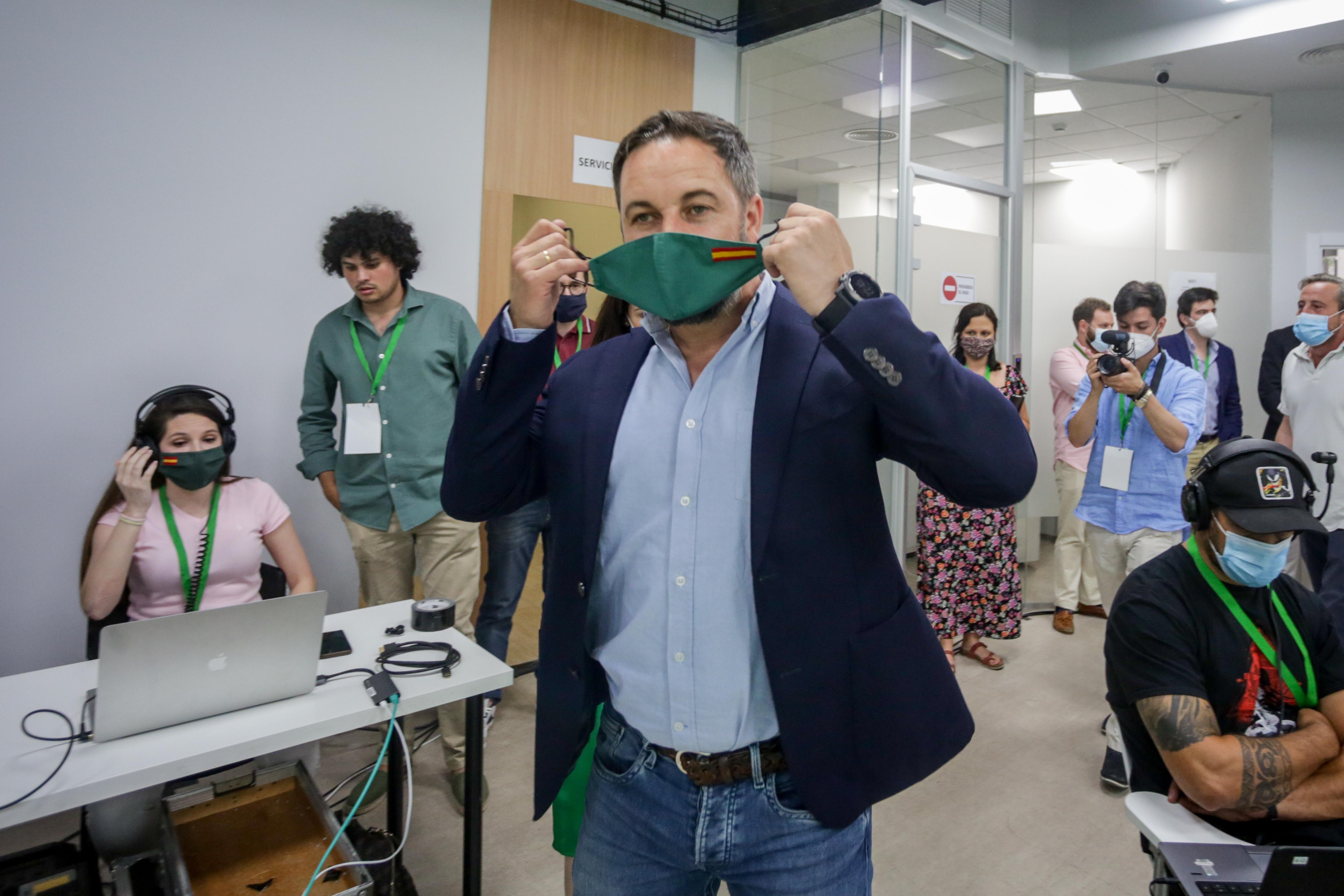 El presidente de Vox, Santiago Abascal, se quita la mascarilla antes de ofrecer una rueda de prensa para valorar los resultados obtenidos por su formación en los comicios vascos y gallegos durante la noche electoral del 12J en la sede del partido