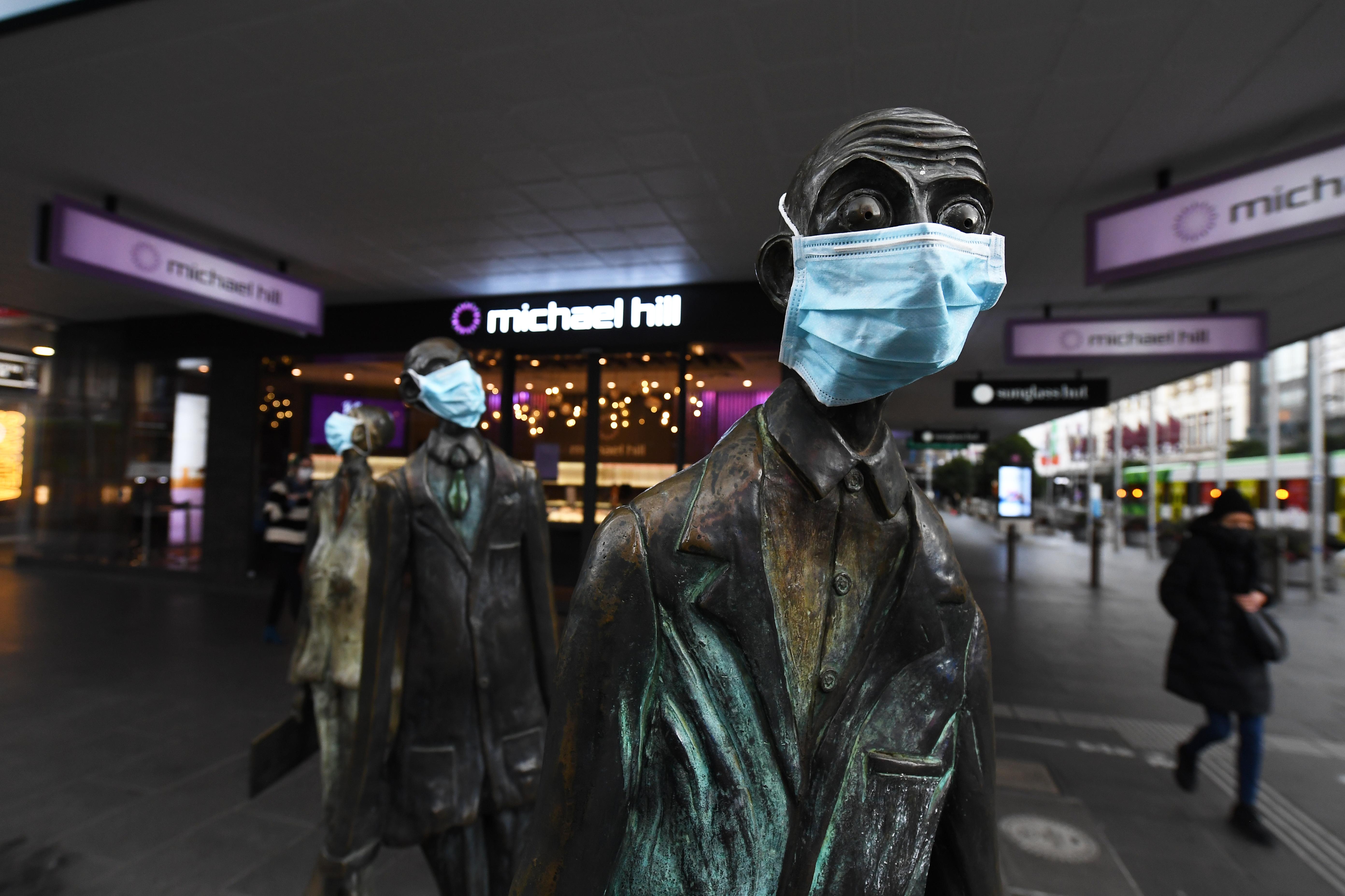 Estatuas con la mascarilla en Swanston Street en Melbourne, Australia.