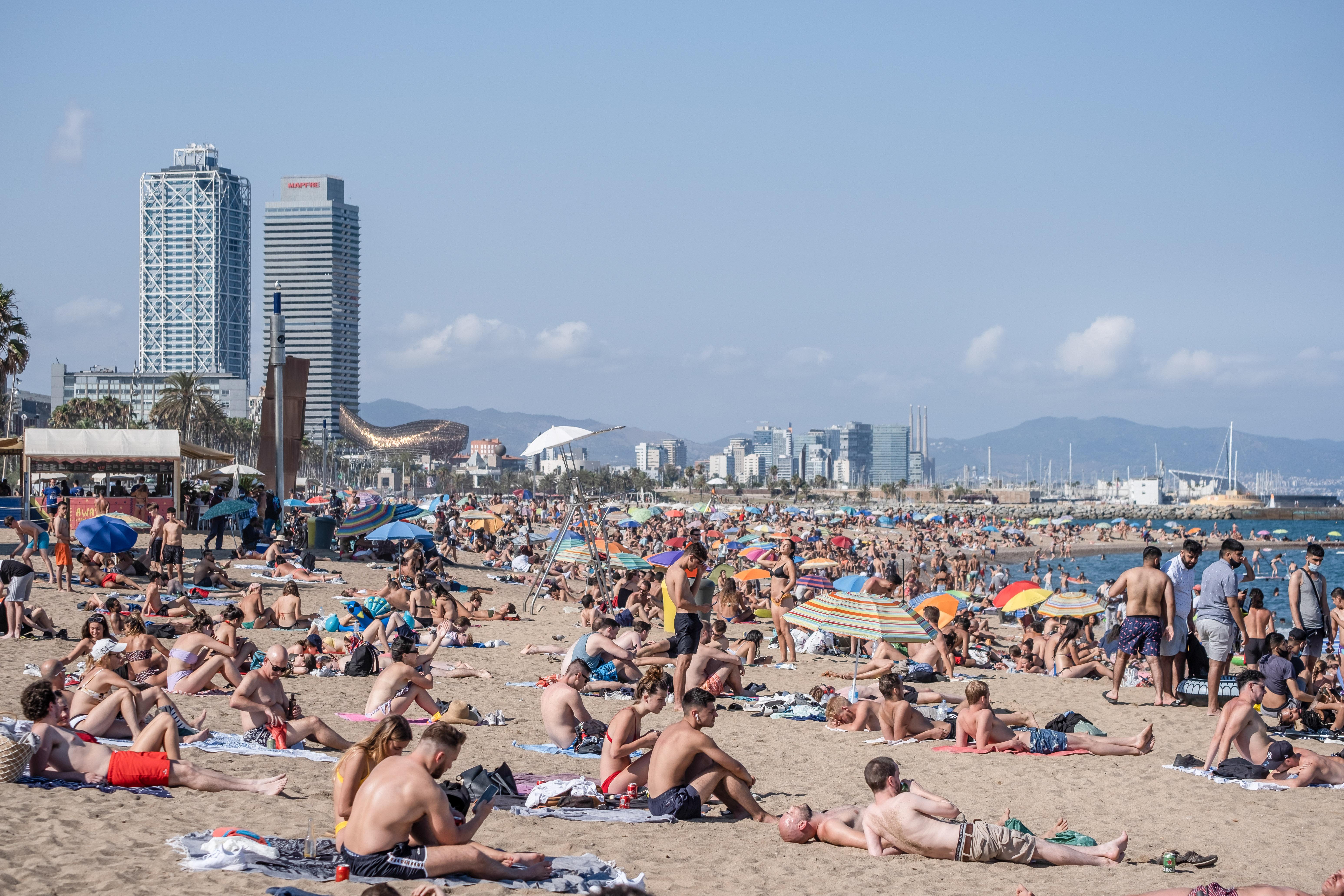 Varias personas toman el sol en una playa de Barcelona