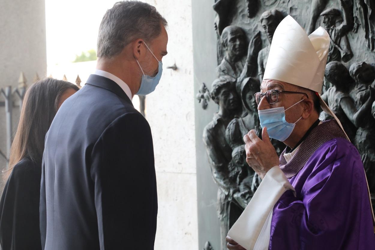 El Rey Felipe VI habla con el presidente de la Conferencia Episcopal Española (CEE) y cardenal arzobispo de Barcelona, Juan José Omella, a su llegada a la entrada de la Santa Misa celebrada en recuerdo de todas las víctimas