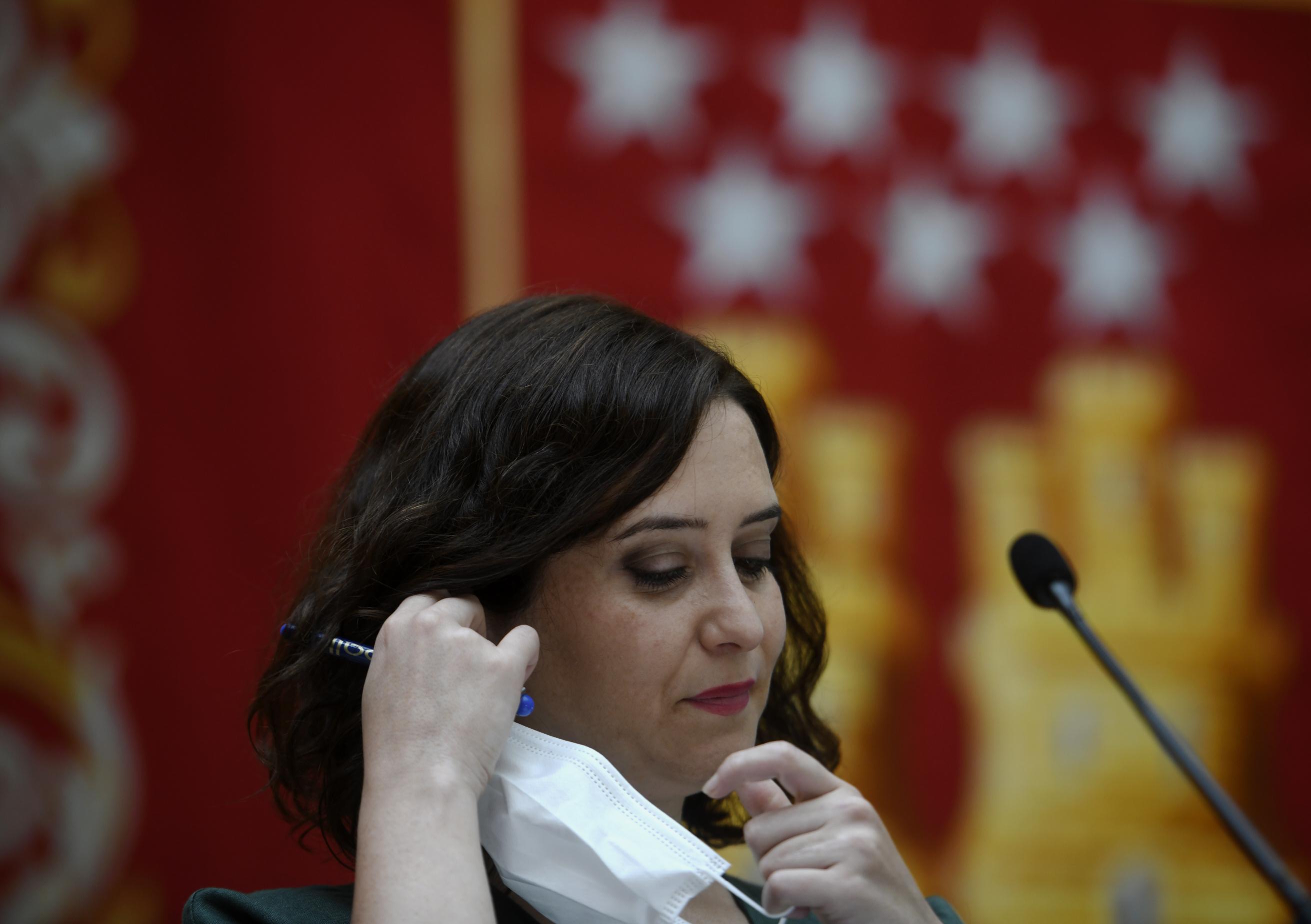 La presidenta de la Comunidad de Madrid, Isabel Díaz Ayuso, se quita la mascarilla antes de presentar la estrategia de continuidad del Covid-19, en la que informa de las nuevas medidas que pondrá en marcha el Gobierno regional para combatir al coronavirus