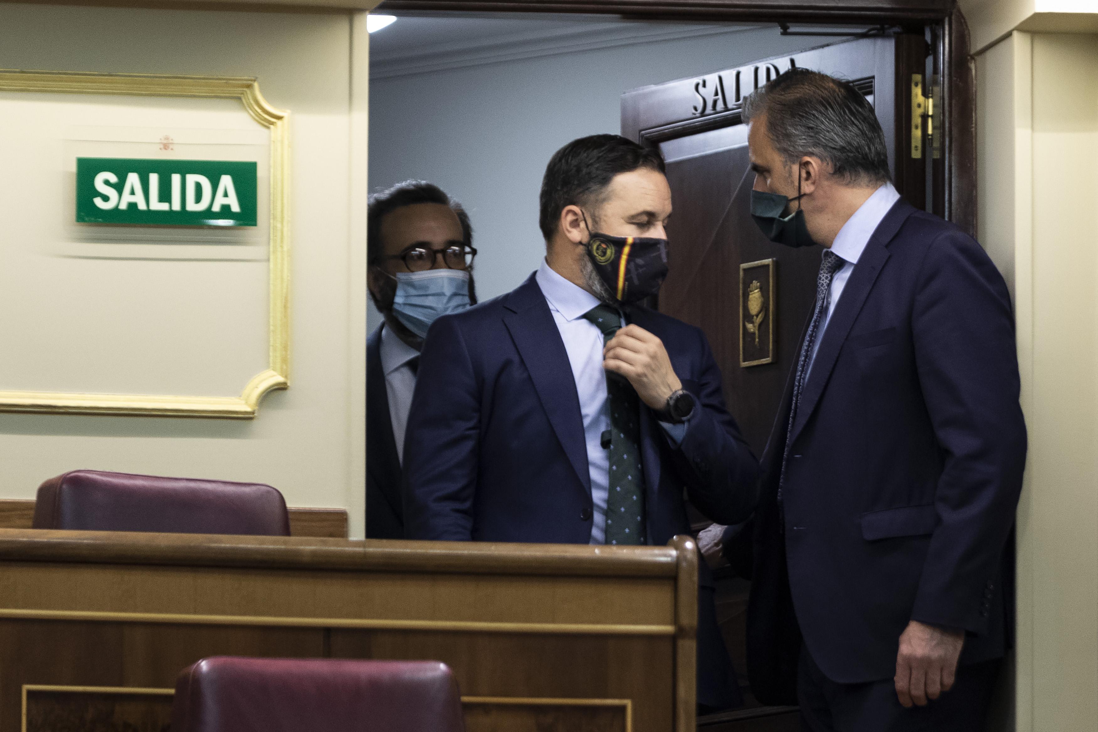  El presidente de Vox, Santiago Abascal (c), habla con el secretario general de Vox, Javier Ortega Smith (1d), a su llegada a una sesión plenaria en el Congreso, en Madrid 