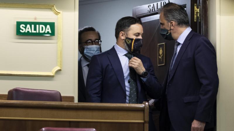 El presidente de Vox, Santiago Abascal (c), habla con el secretario general de Vox, Javier Ortega Smith (1d), a su llegada a una sesión plenaria en el Congreso, en Madrid