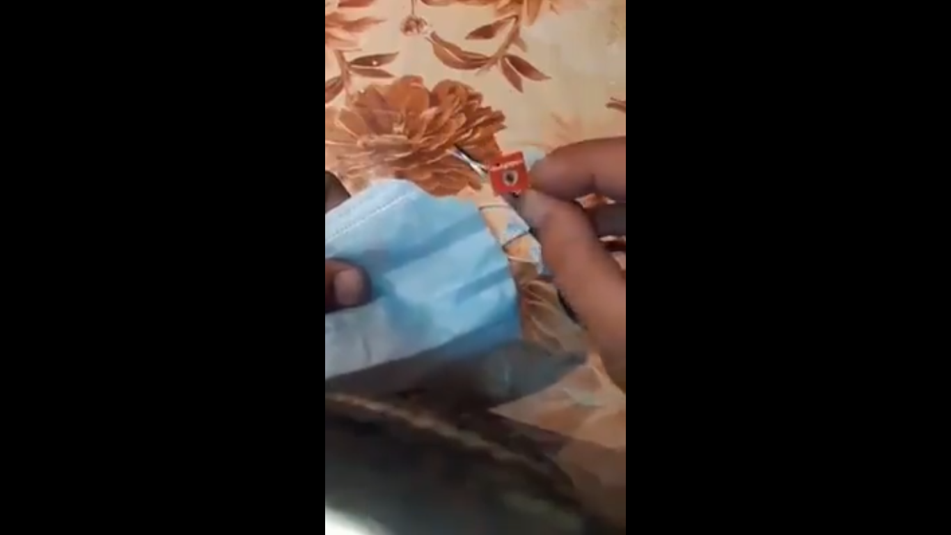 Momento del vídeo en el que el autor extrae una tarjeta SIM de la mascarilla