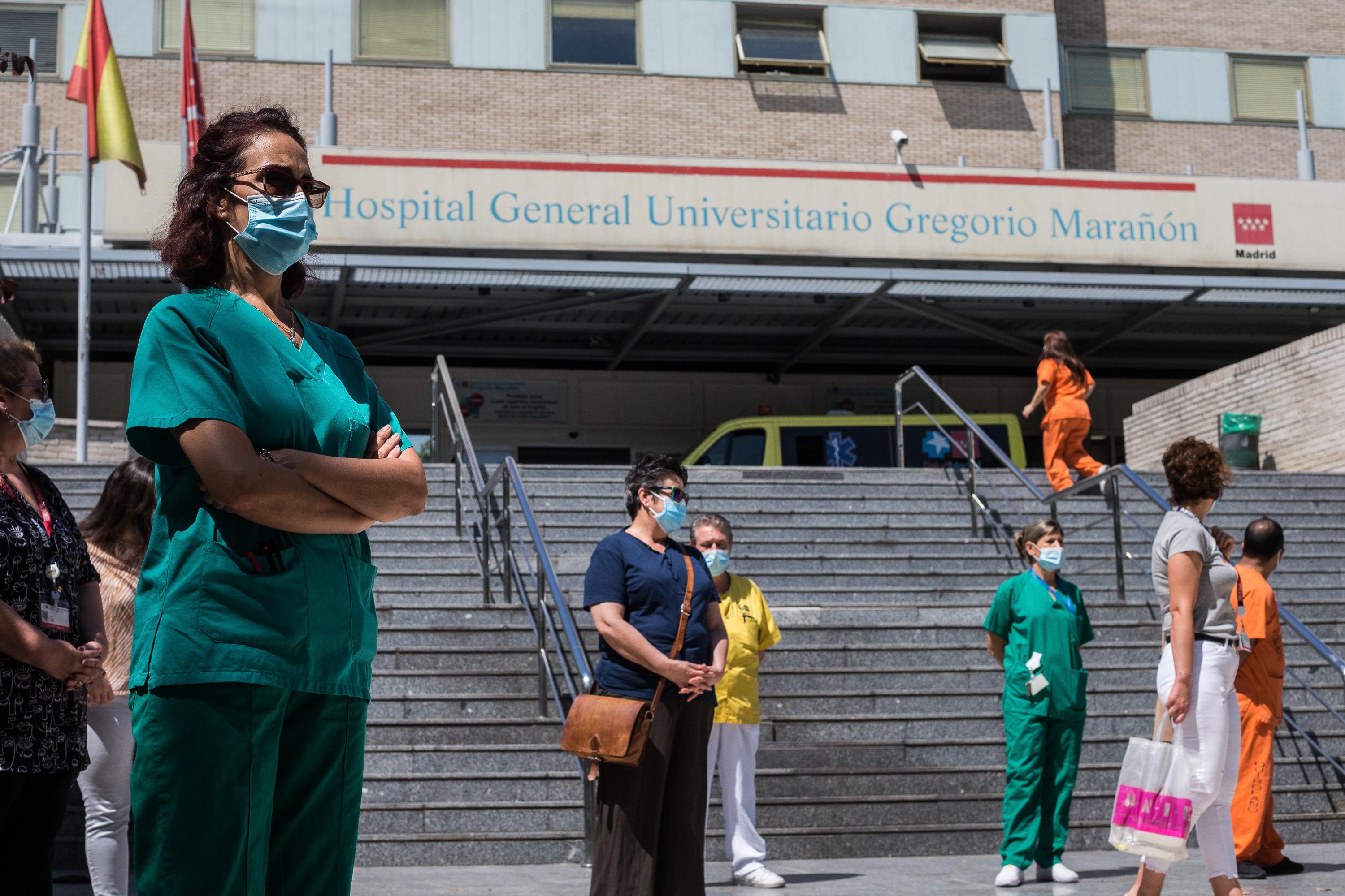 Trabajadores sanitarios protegidos con mascarilla durante la concentración convocada donde decenas de celadores se han congregado a las puertas del Hospital General Universitario Gregorio Marañón, tras ser excluidos de la catalogación de personal de riesg