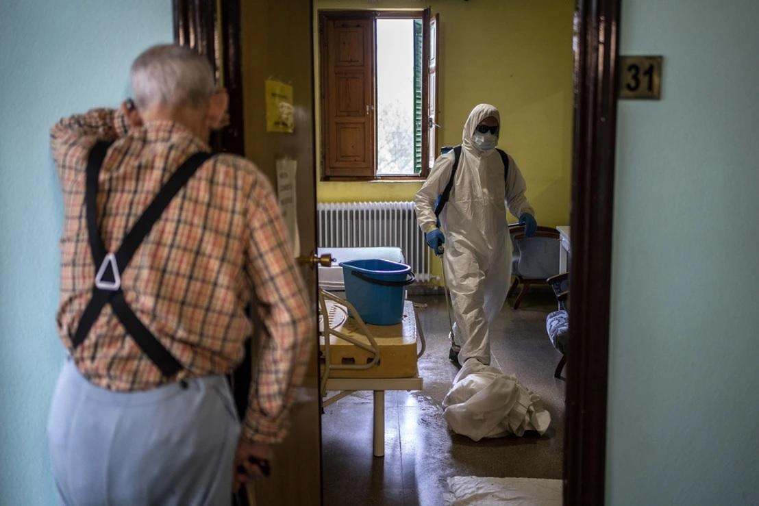Desinfección en una residencia ante la mirada de un anciano. EP