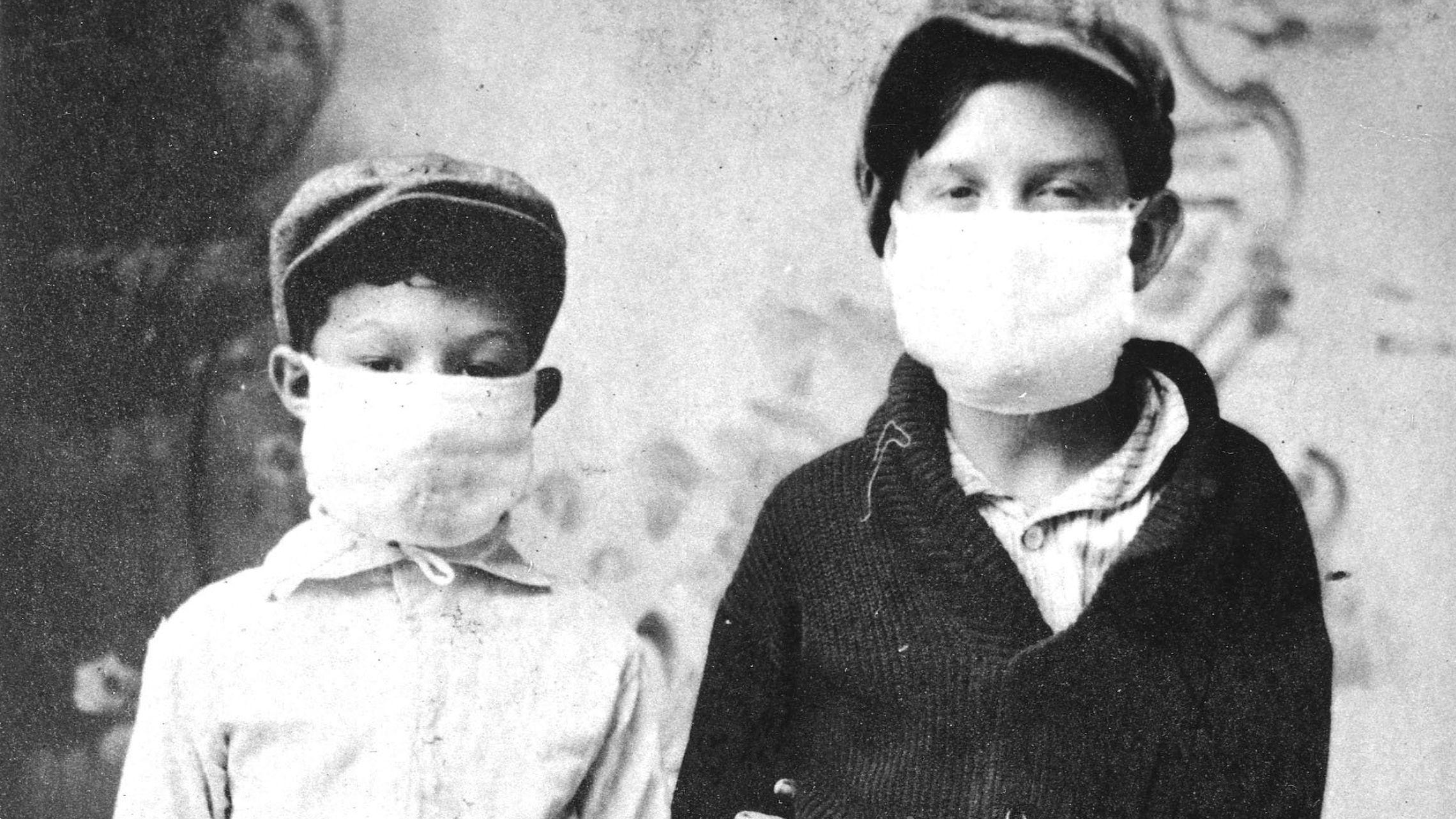 Dos niños con mascarillas de tela en 1918.