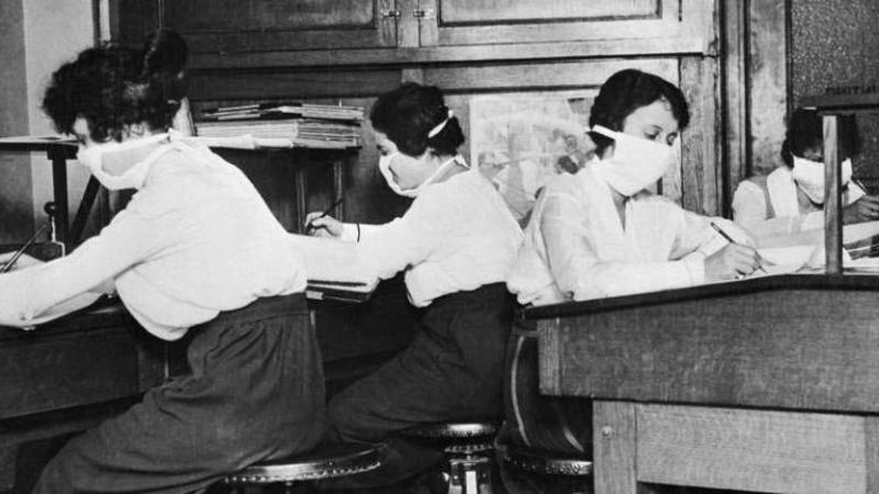 Mujeres estudiando con mascarillas de tela.