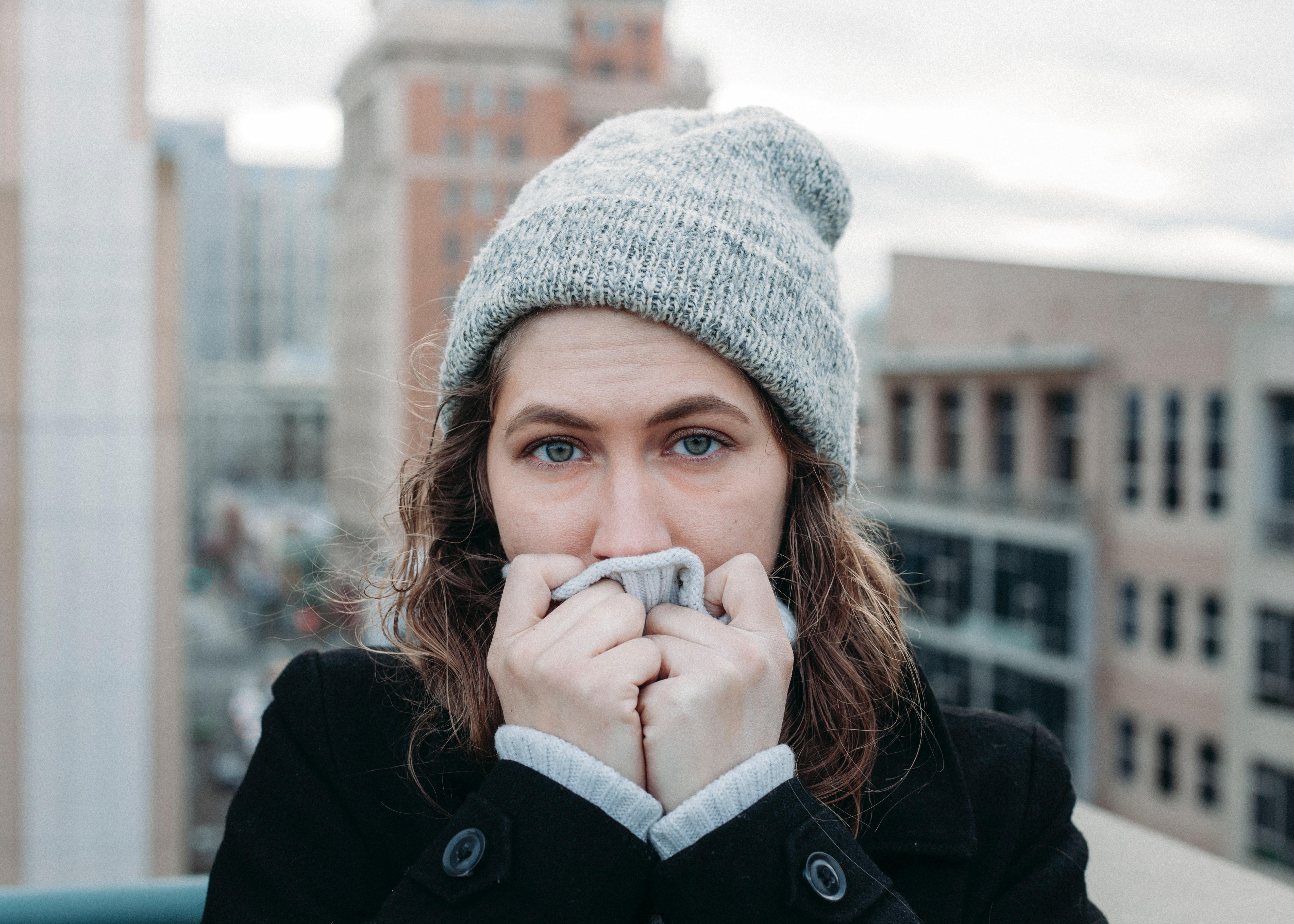 Mujer con gorro cubriéndose la boca. Unsplash