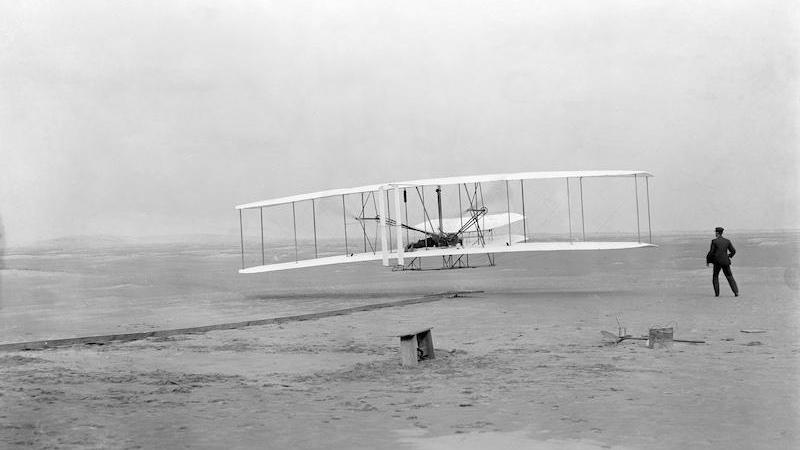 Primer vuelo de los Hemanos Wright. (DP) Foto de John T. Daniels -  Biblioteca del Congreso de los Estados Unidos bajo el código digital cph.3a53266.