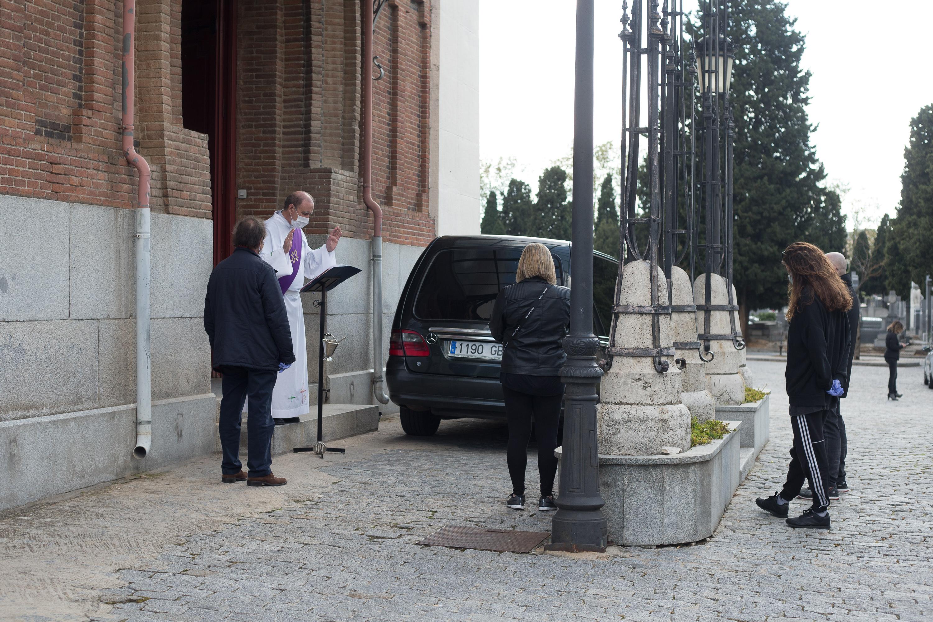 El Padre Santiago oficia el responso a un fallecido por coronavirus en el Cementerio de la Almudena durante la pandemia de coronavirus en Madrid. EP.