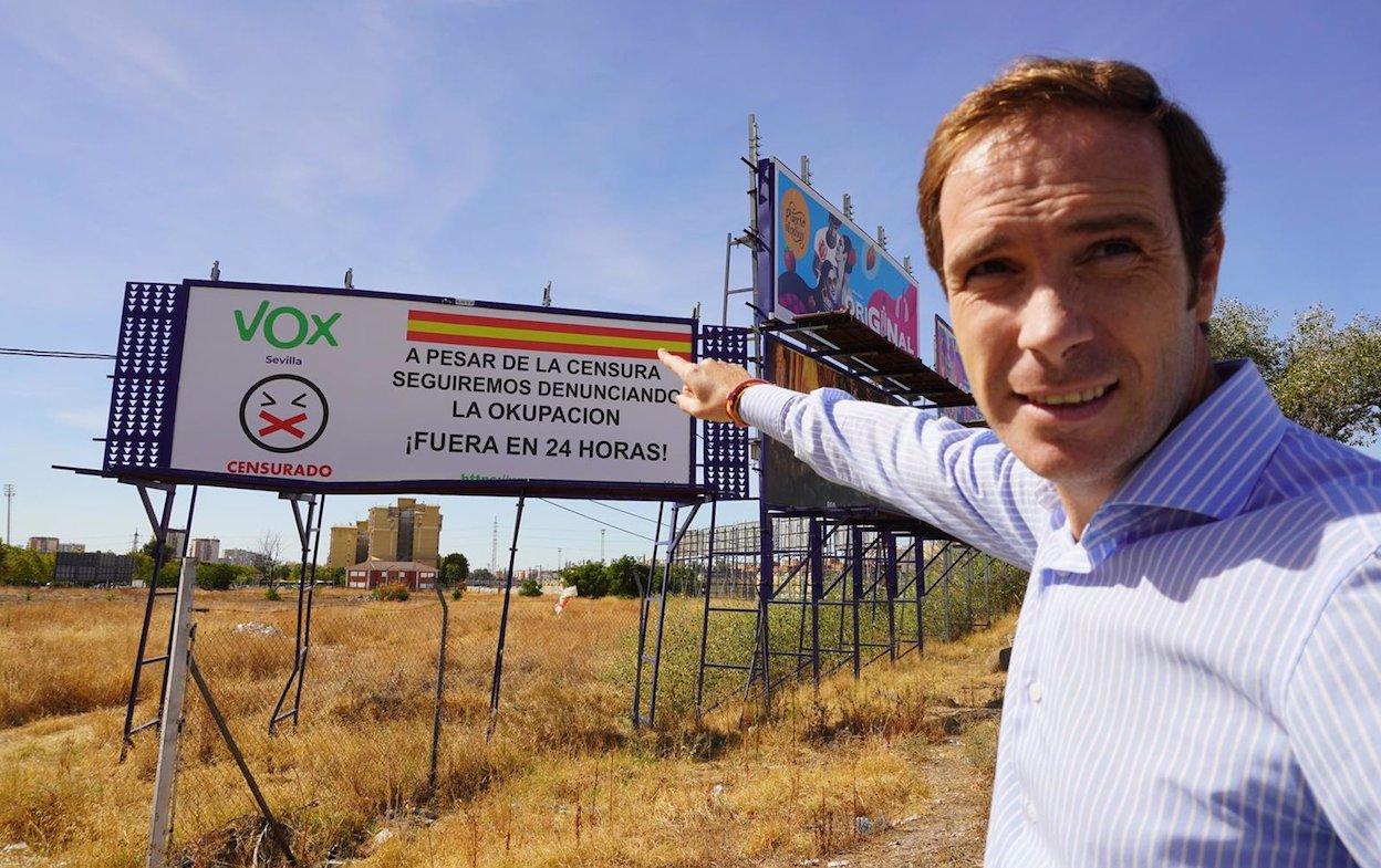 El presidente de Vox Sevilla, Javier Cortés, señala la valla "censurada" por Autocontrol.