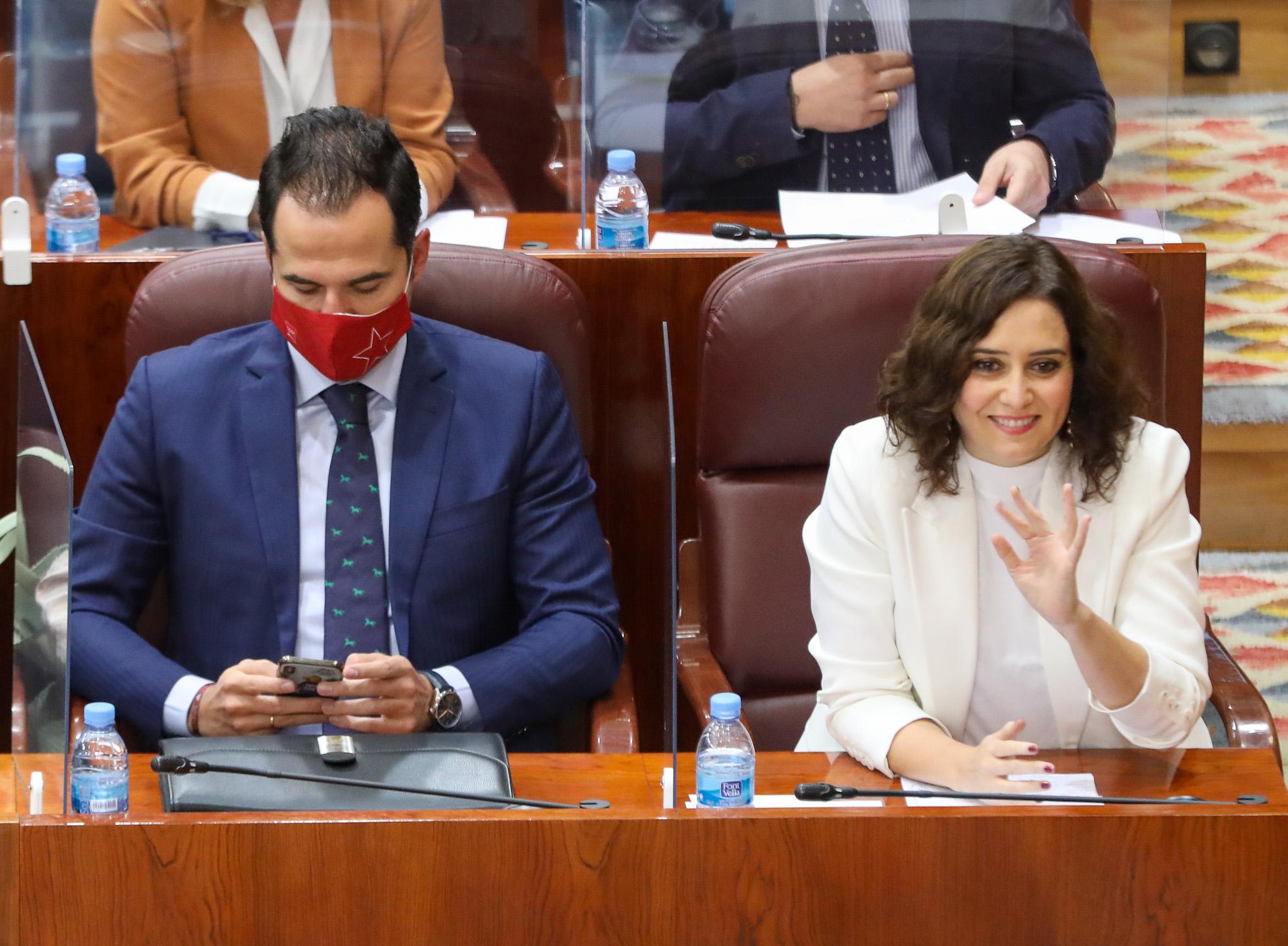La presidenta de la Comunidad de Madrid, Isabel Díaz Ayuso, saluda al lado del vicepresidente de la Comunidad de Madrid, Ignacio Aguado, durante una sesión plenaria en la Asamblea de Madrid 