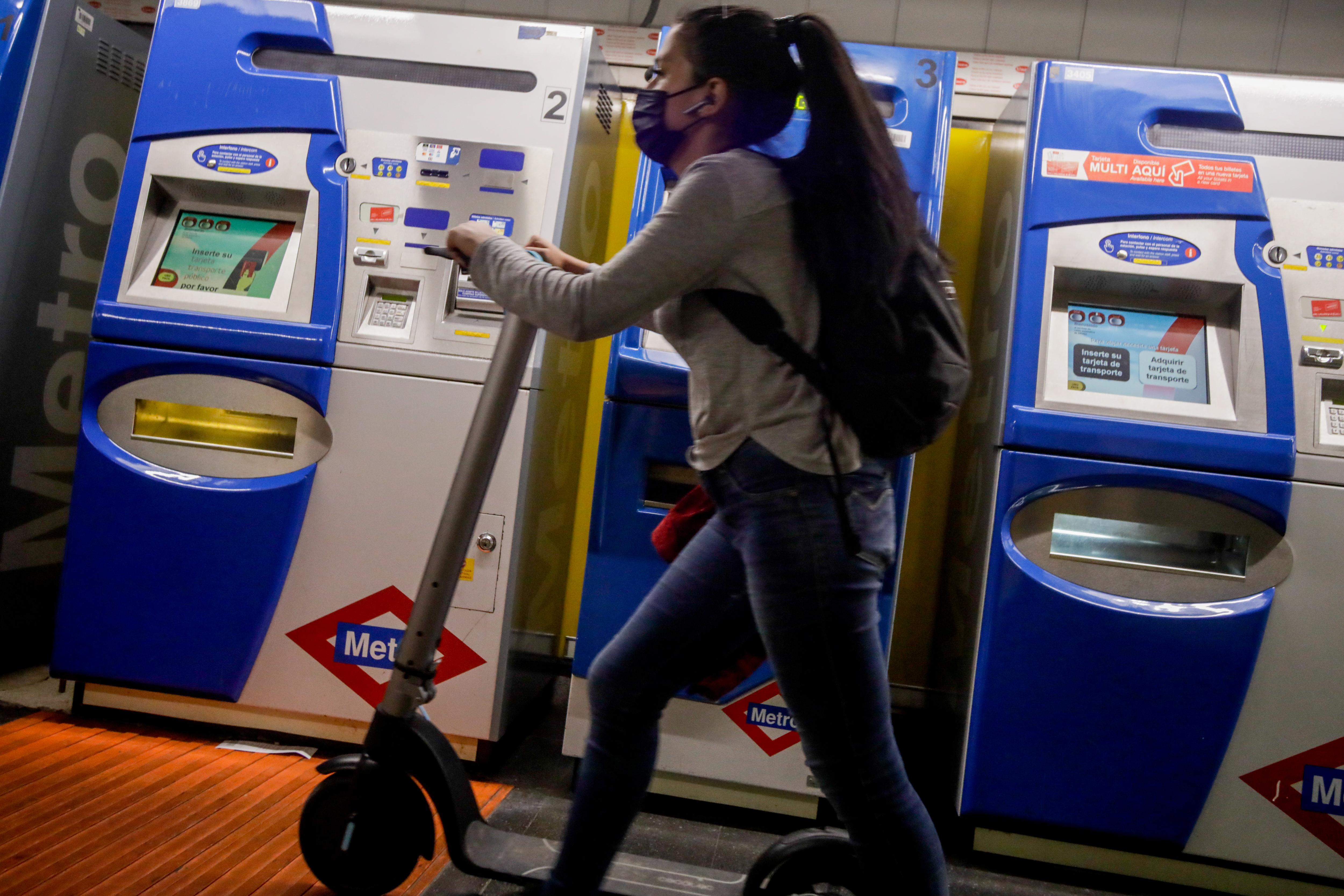 Una mujer entra con un patinete eléctrico en el metro de Ciudad Lineal, Madrid (España)