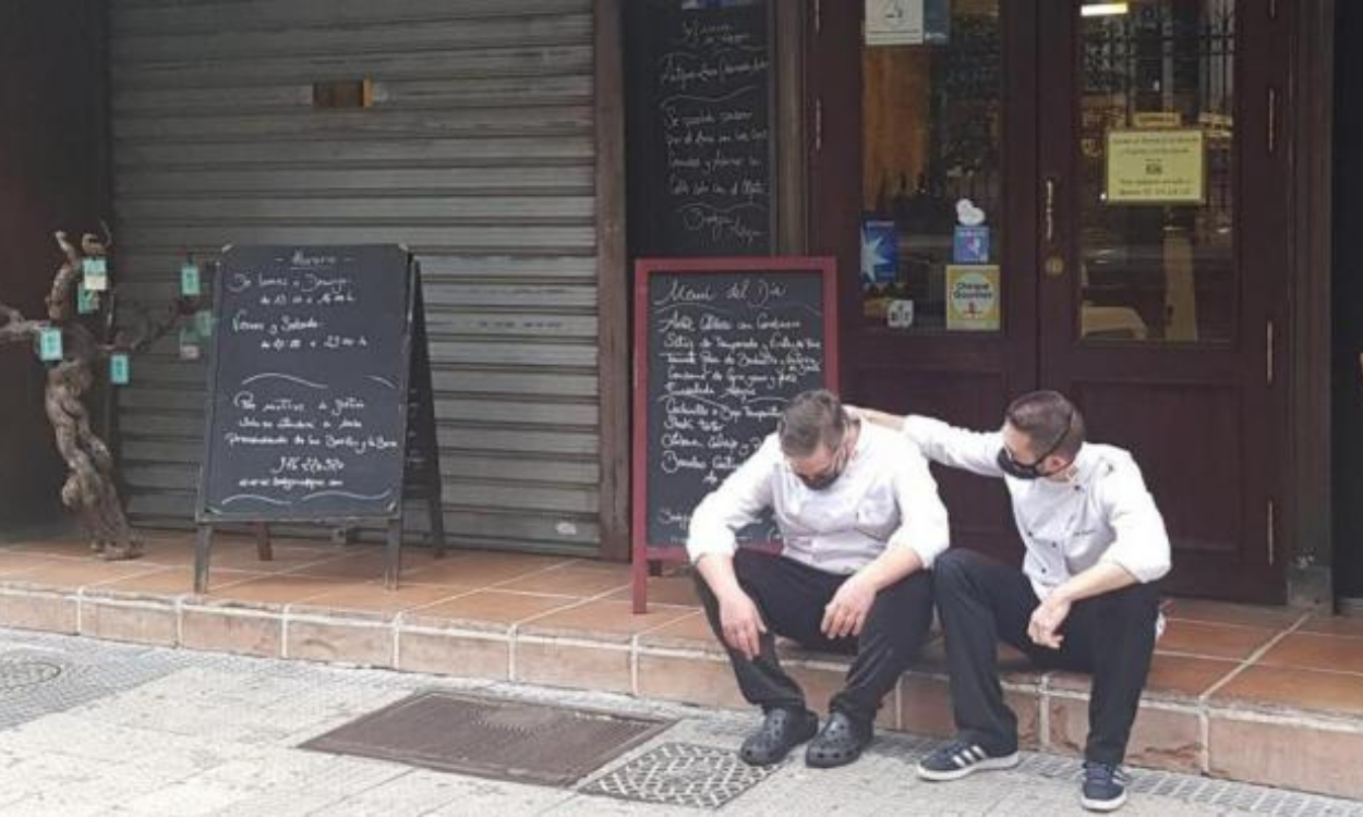 El chef devastado a las puertas de su restaurante, consolado por un camarero. Fuente: El Heraldo.